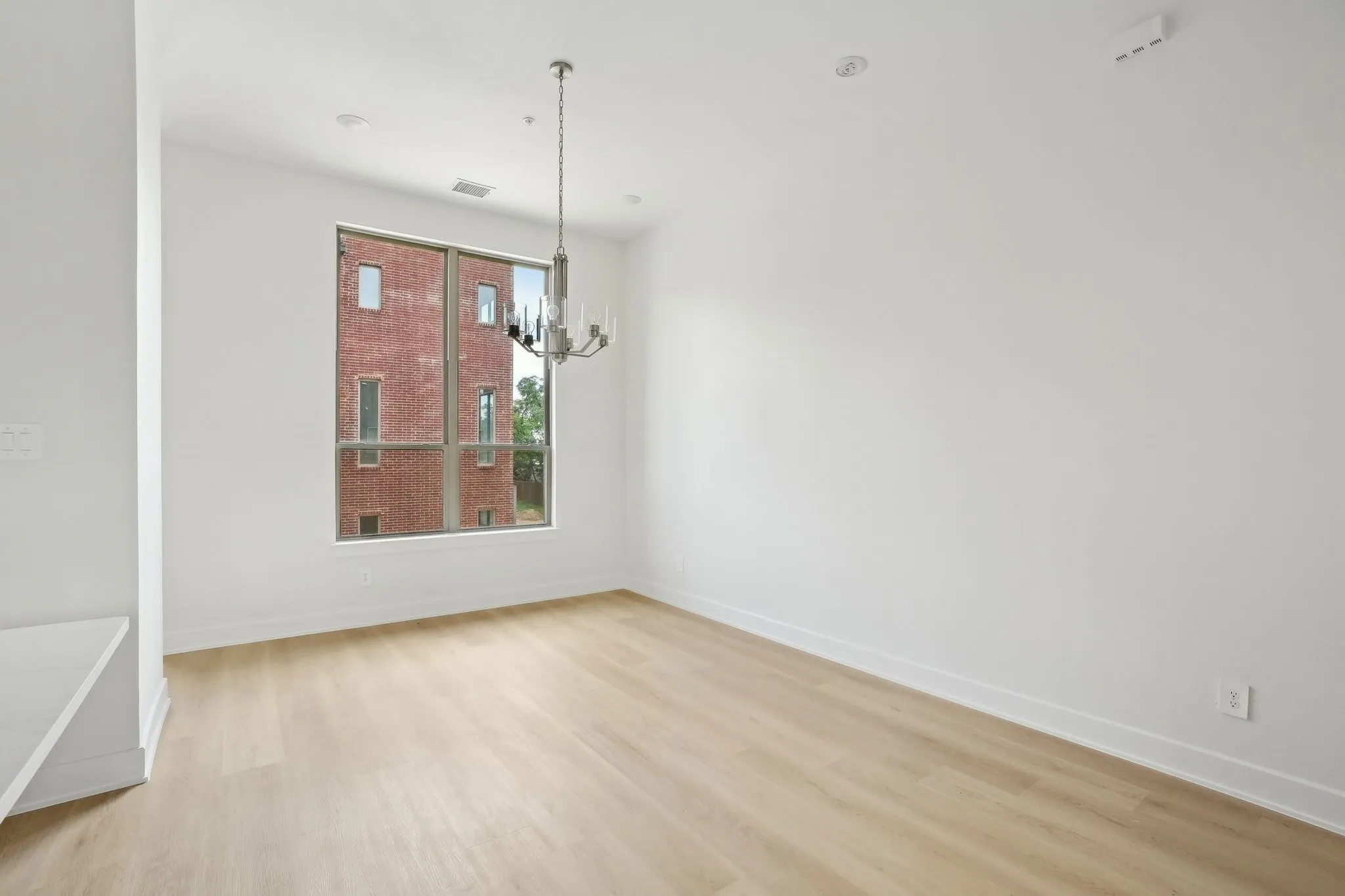 Unfurnished room featuring light wood-type flooring and a chandelier