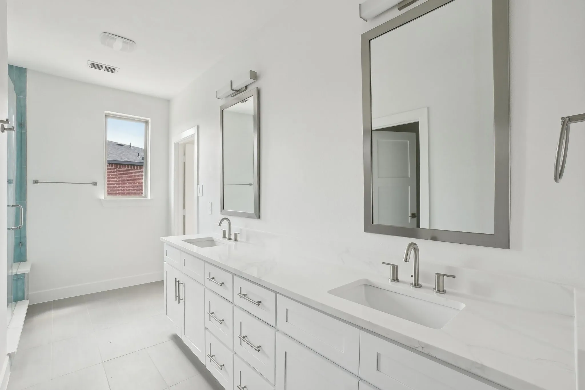 Bathroom with double vanity, a stall shower, and light tile patterned flooring