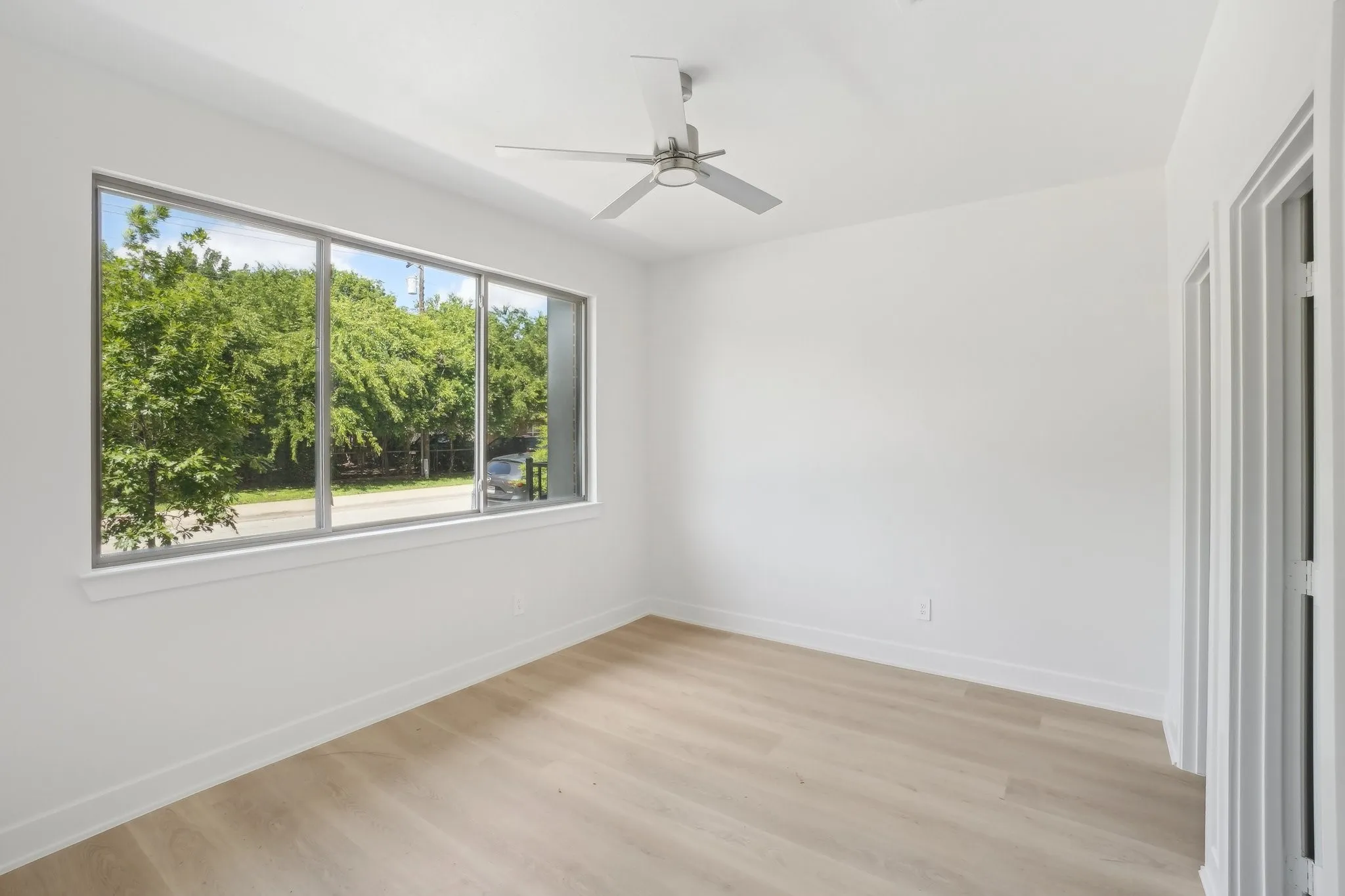 Empty room featuring light wood finished floors and a ceiling fan