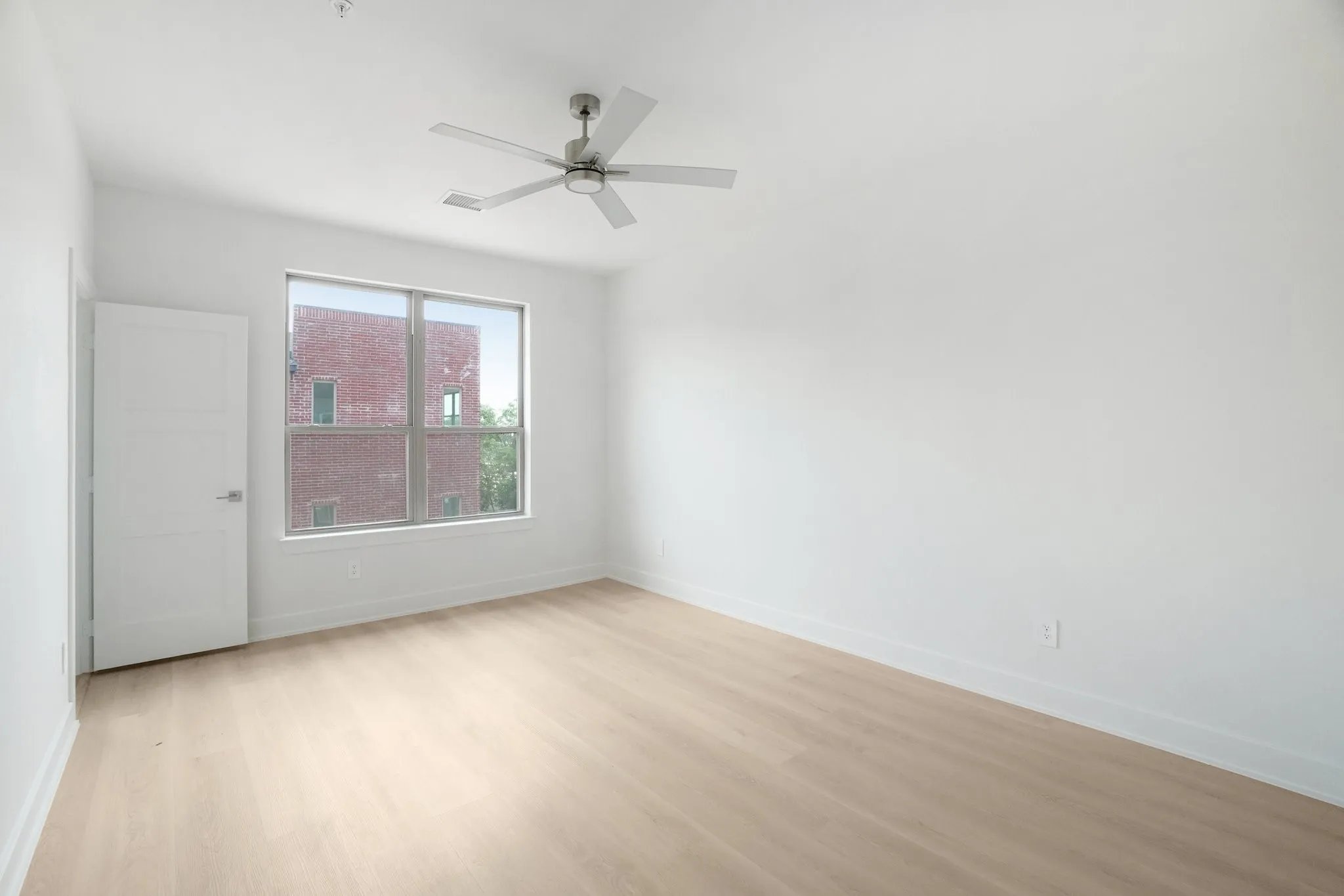 Empty room featuring light wood-type flooring and ceiling fan