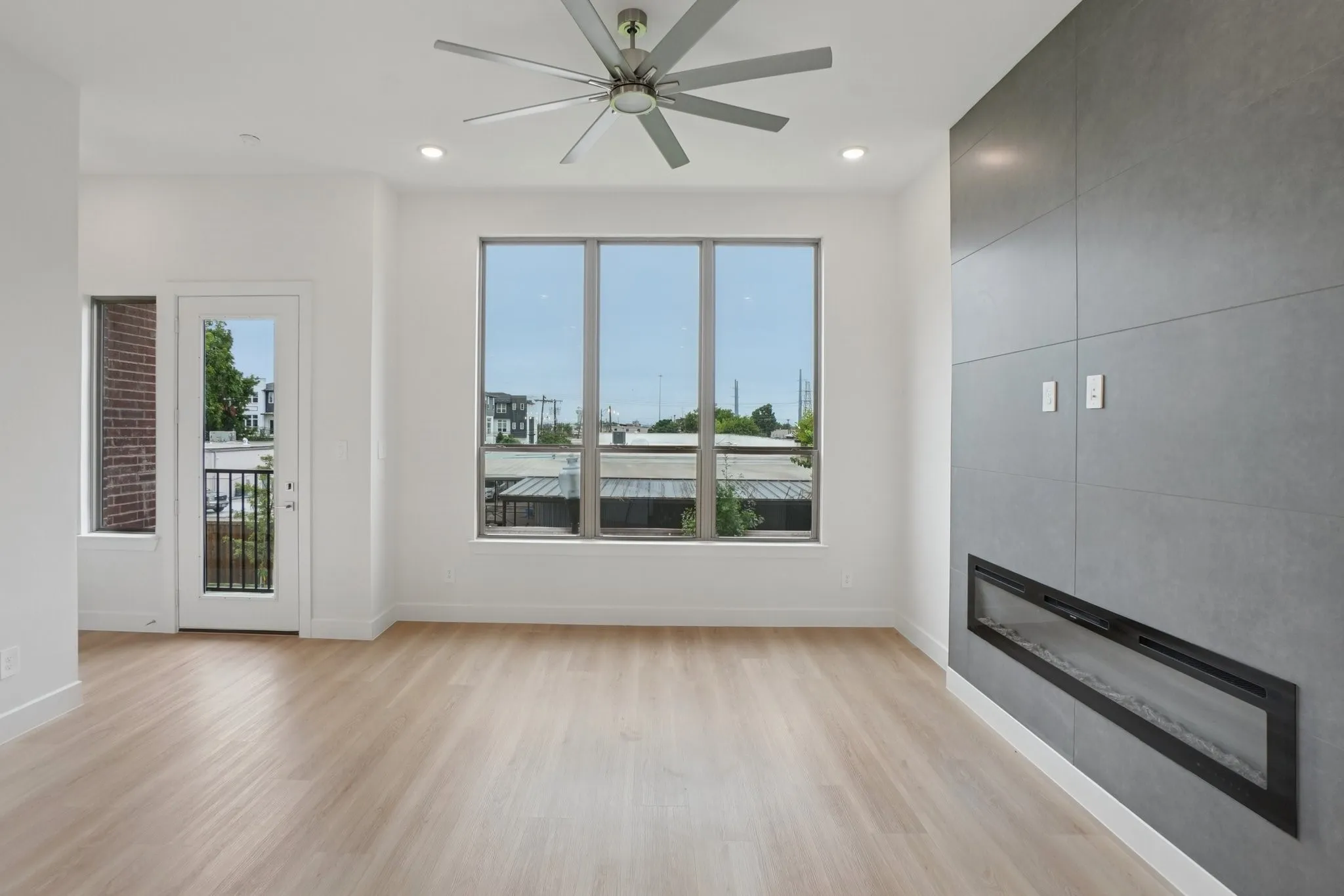 Unfurnished living room featuring light wood-style floors, a large fireplace, ceiling fan, and recessed lighting