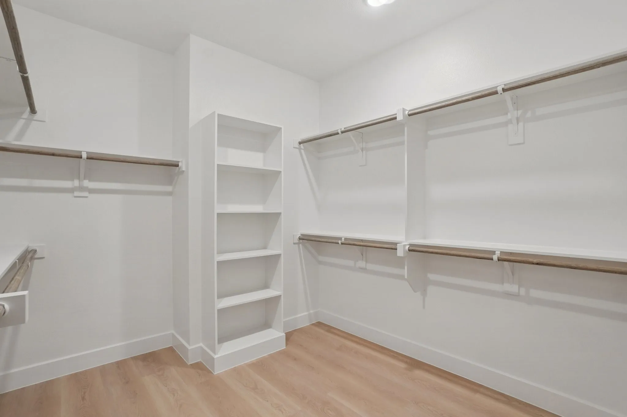 Walk in closet with light wood-style floors