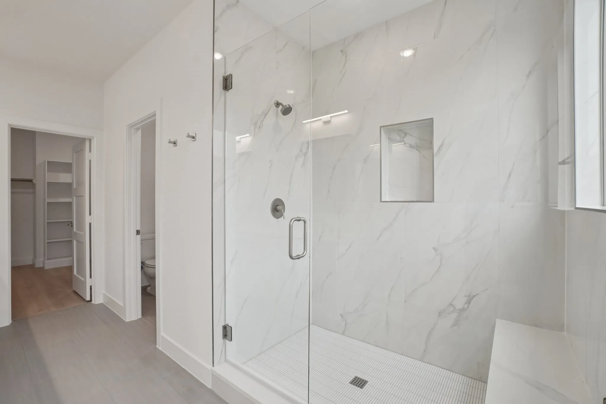 Full bathroom with a walk in closet and a marble finish shower