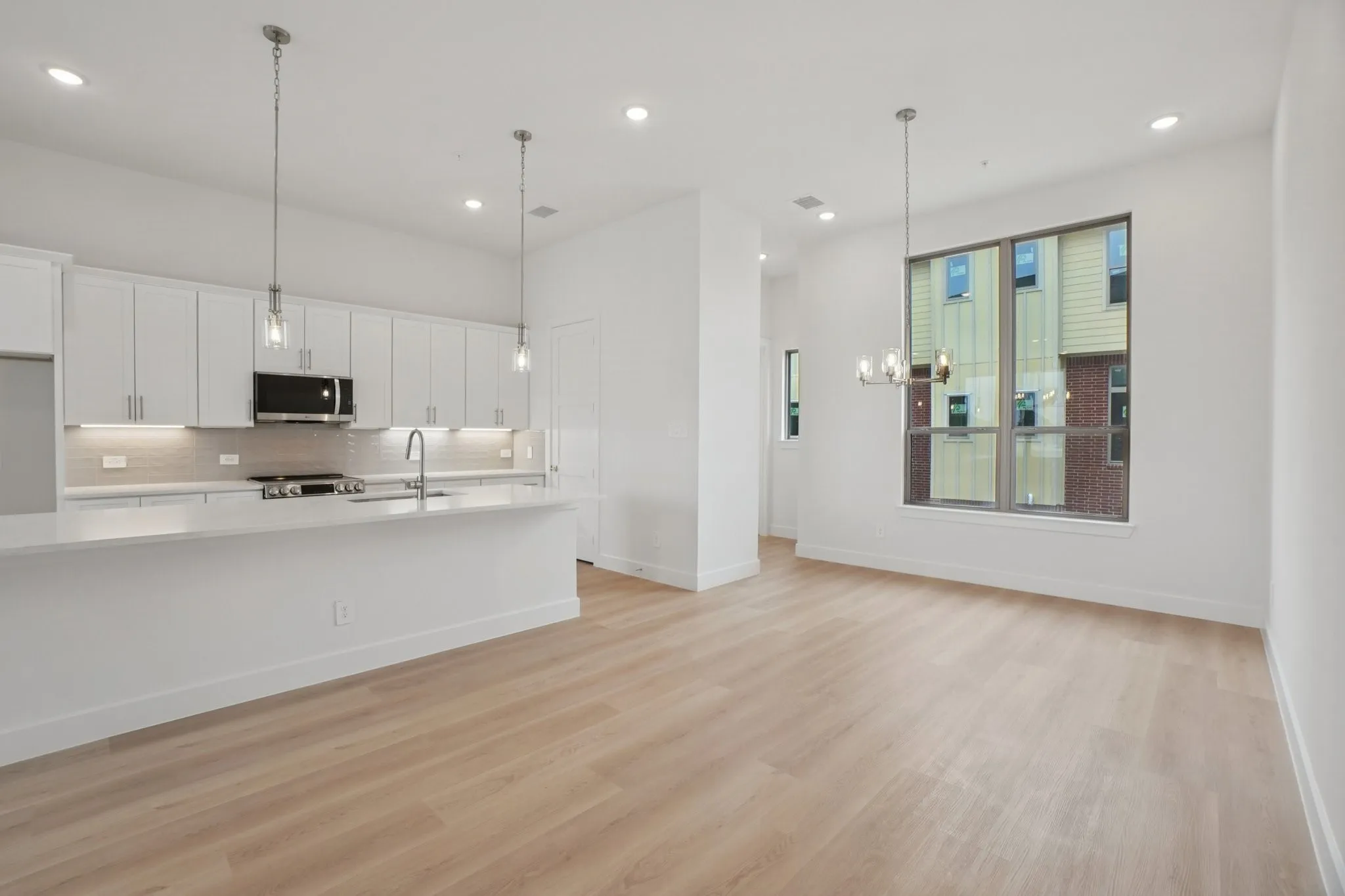 Living room with light wood-style floors, recessed lighting, and a chandelier