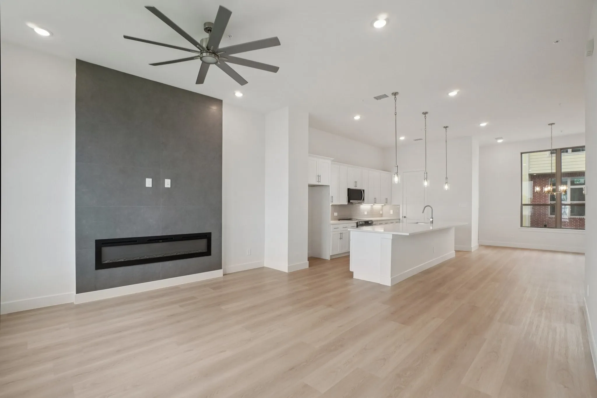 Unfurnished living room with a fireplace, a chandelier, light wood-style floors, recessed lighting, and ceiling fan