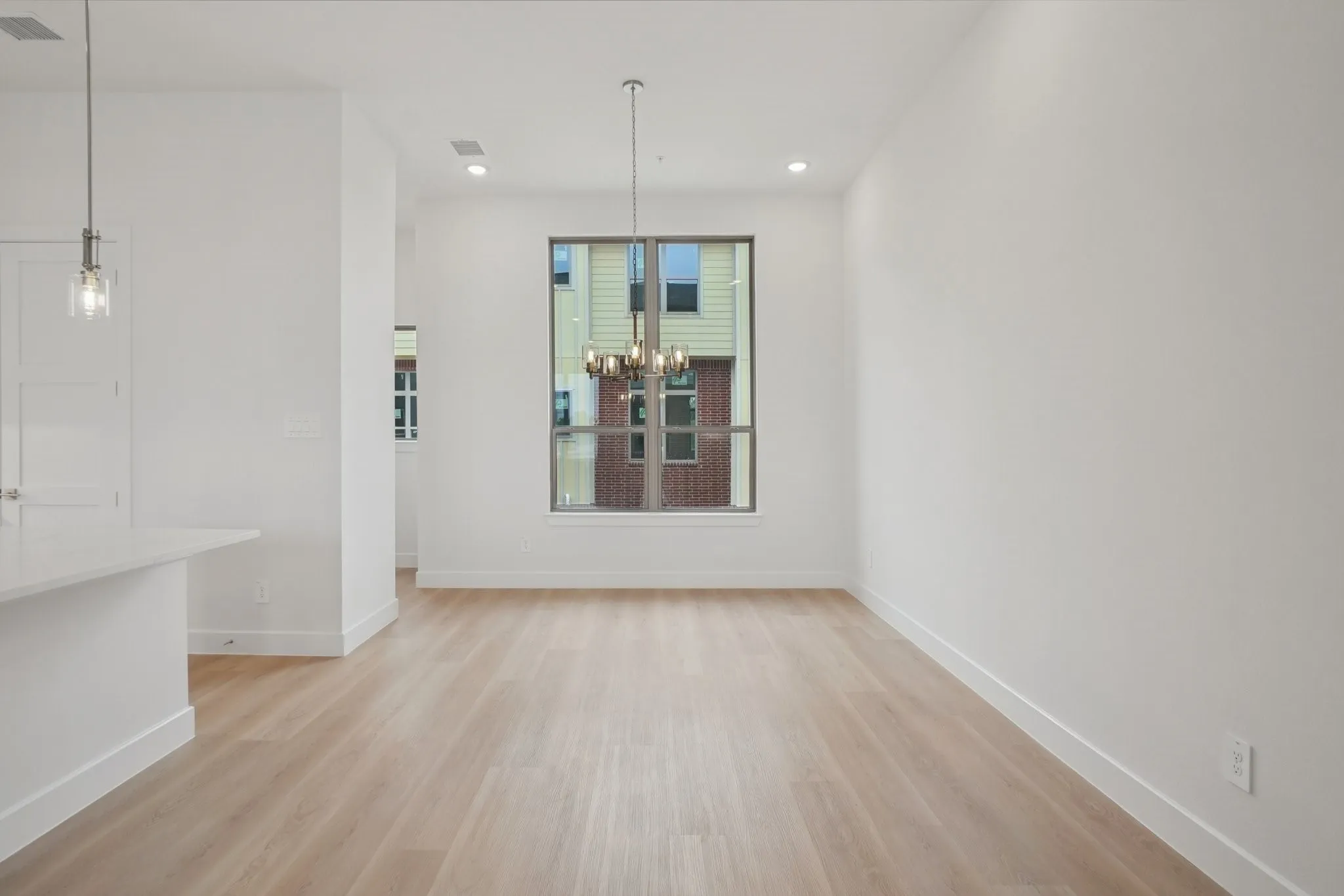 Unfurnished dining area with light wood finished floors, a chandelier, and recessed lighting