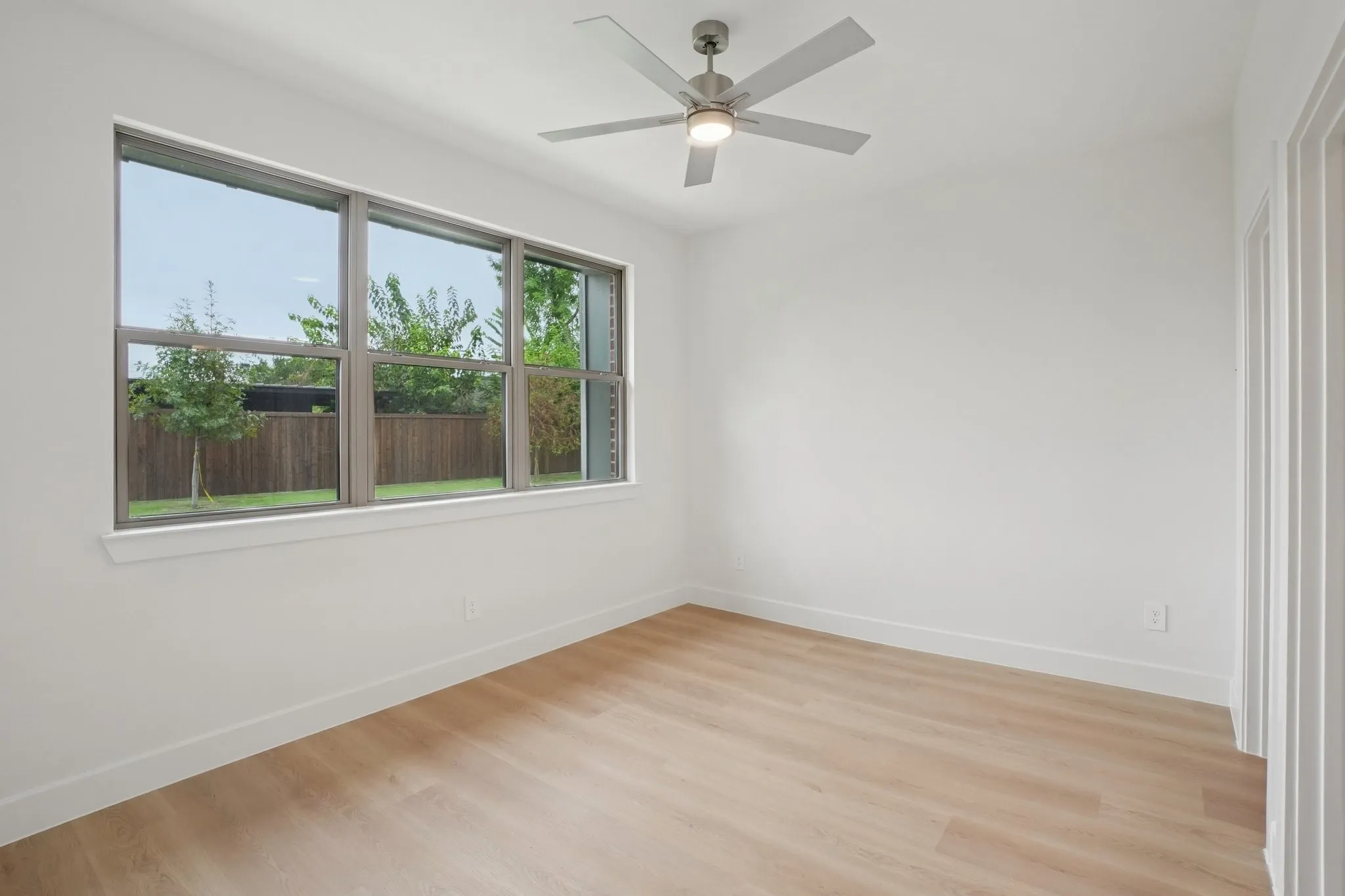 Empty room with light wood-type flooring and ceiling fan