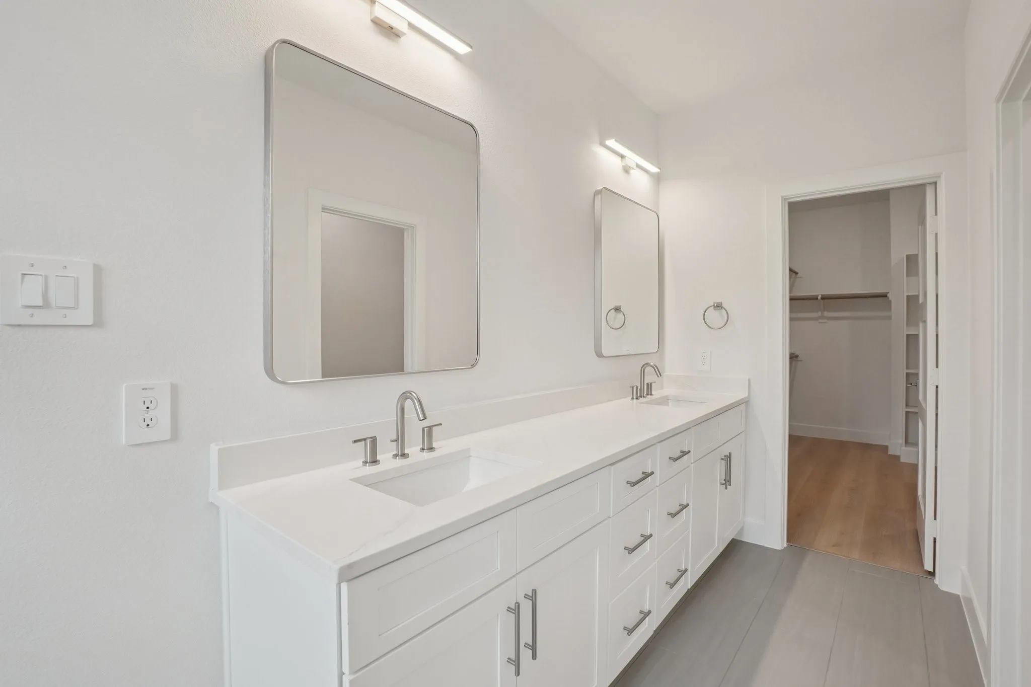Bathroom featuring double vanity and a walk in closet