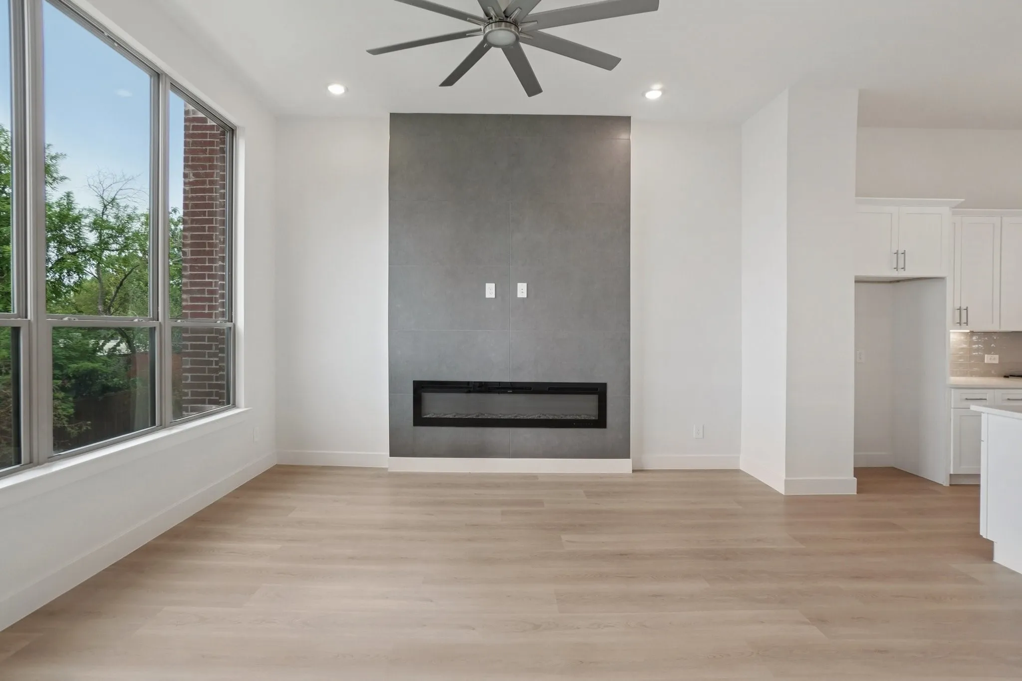 Unfurnished living room featuring light wood-style flooring, a fireplace, recessed lighting, and a ceiling fan