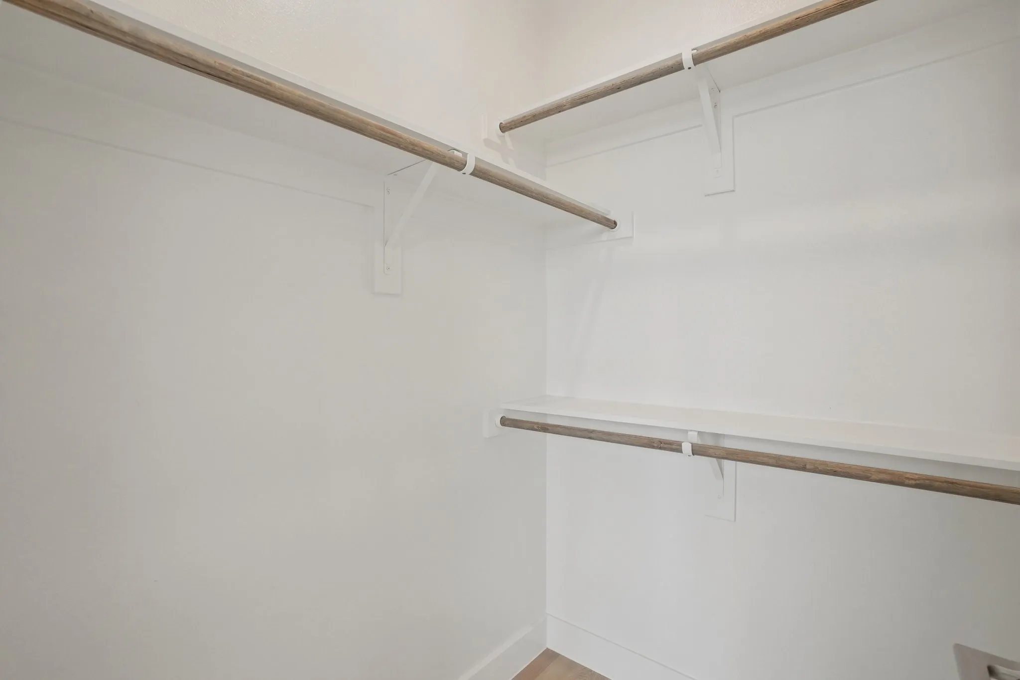Walk in closet with wood finished floors
