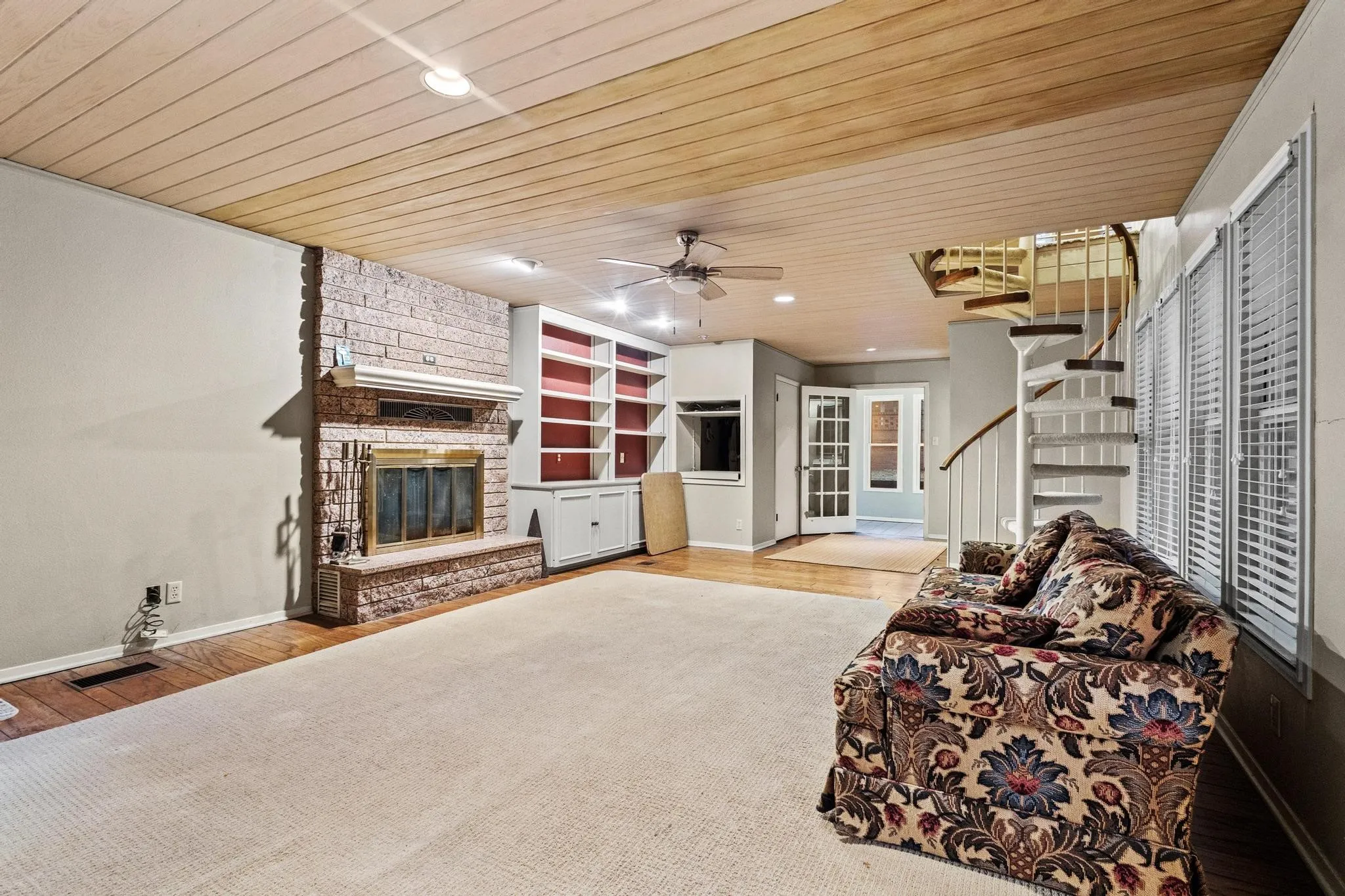 Living room with built ins, media closet, fireplace and spiral staircase to master