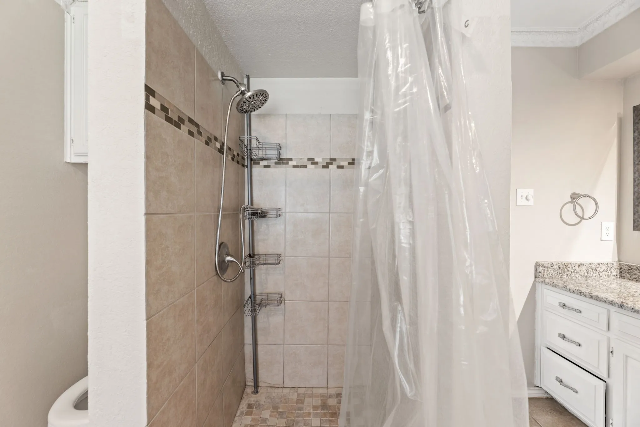 Bathroom with vanity, a stall shower, and a textured ceiling