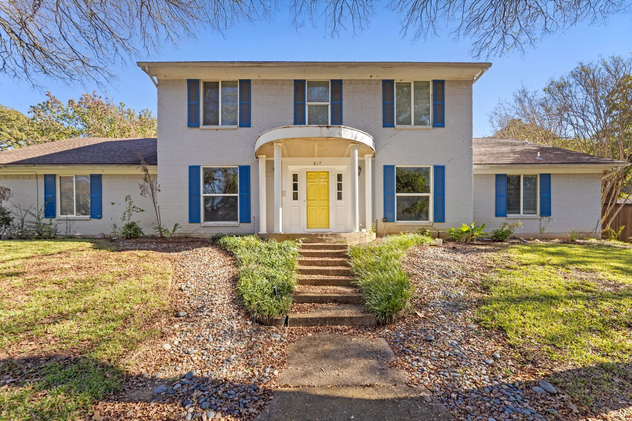 Colonial house with brick siding and a front yard