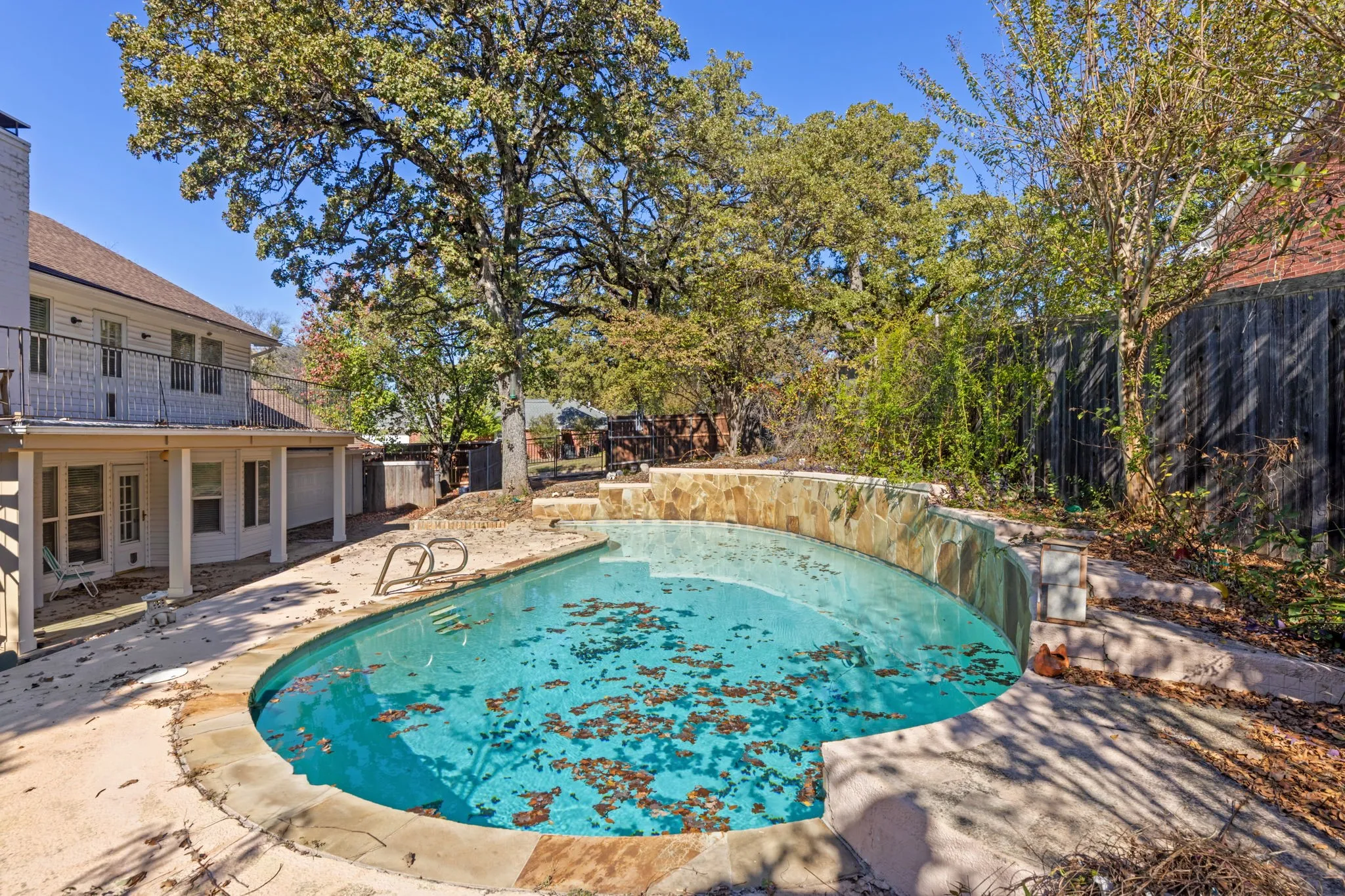 View of pool featuring a patio area, a fenced backyard, and a balcony