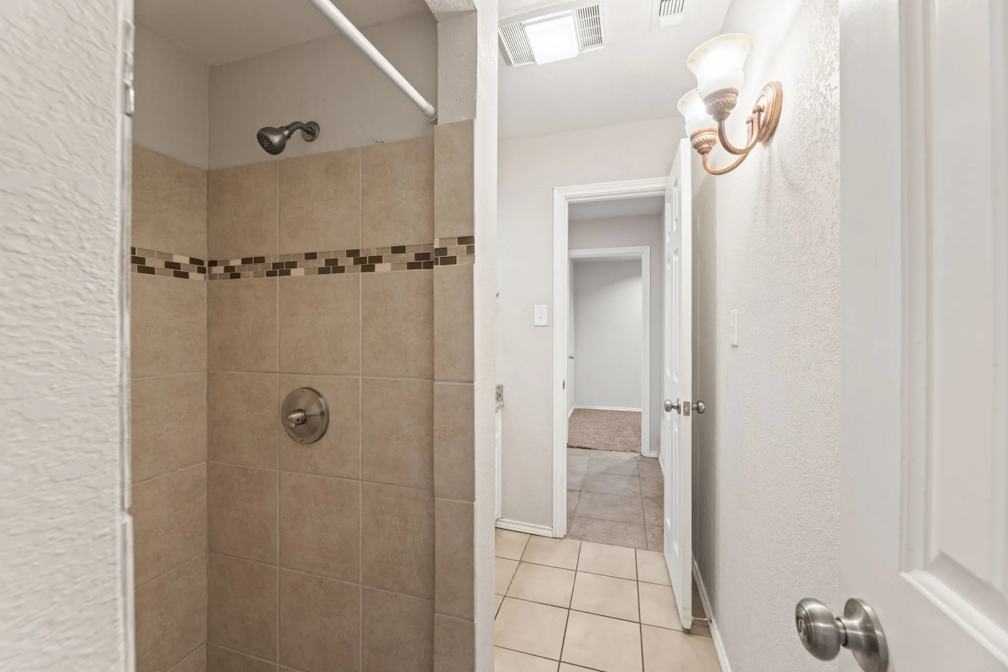 Full bathroom featuring a stall shower and tile patterned flooring