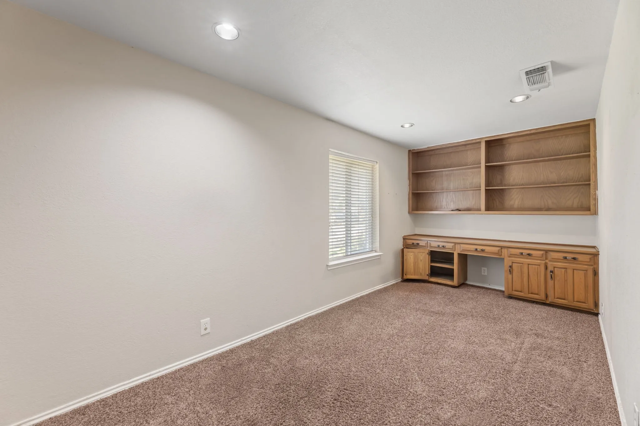 Unfurnished office featuring built in study area, light colored carpet, and recessed lighting