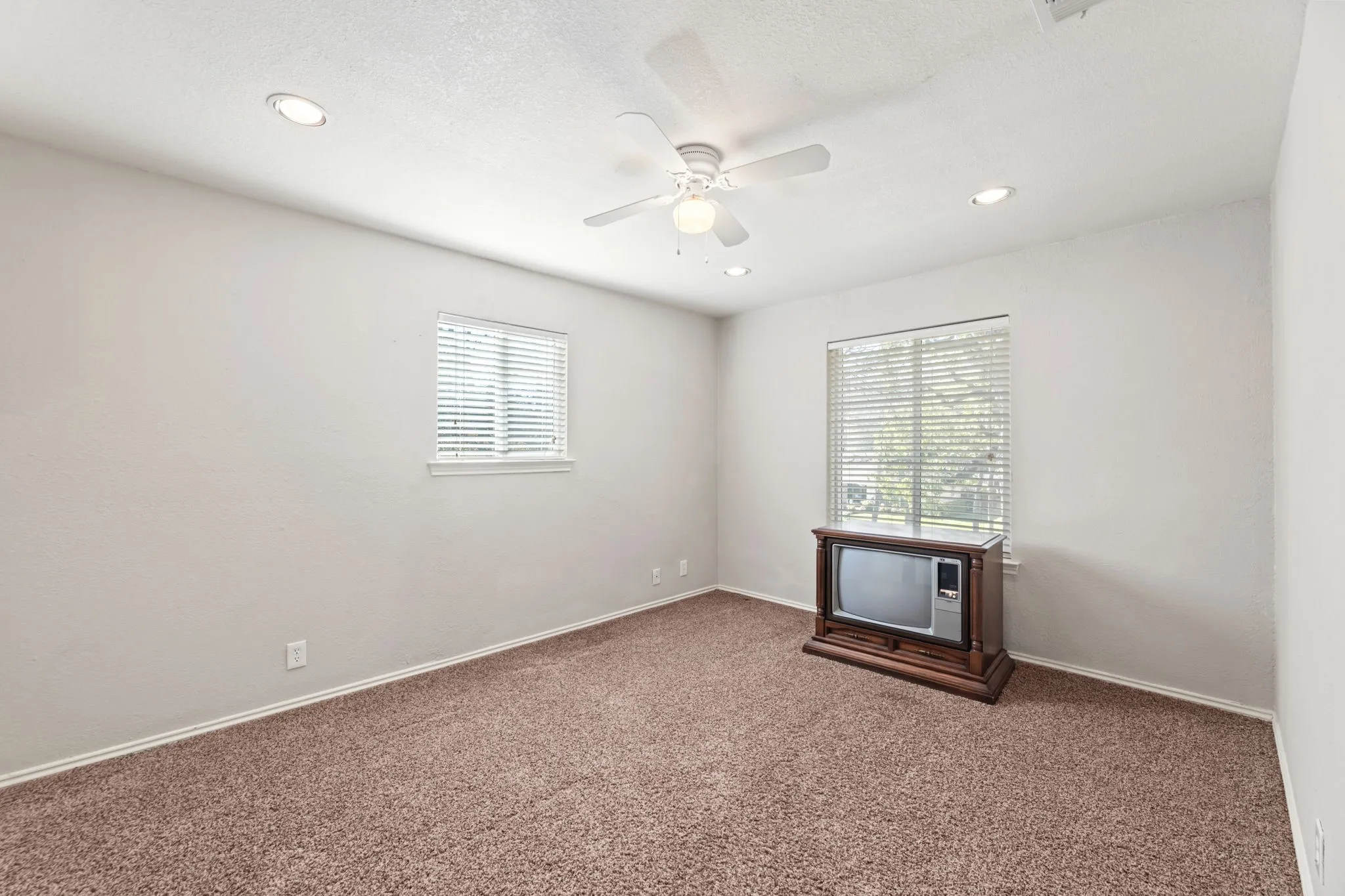 Carpeted empty room featuring a ceiling fan and recessed lighting