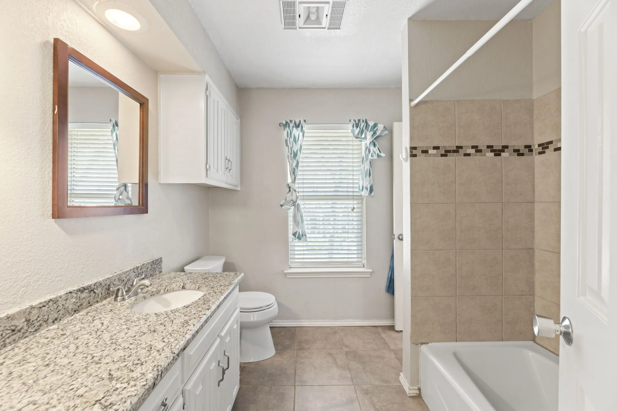 Full bathroom featuring vanity, shower / tub combination, and light tile patterned floors