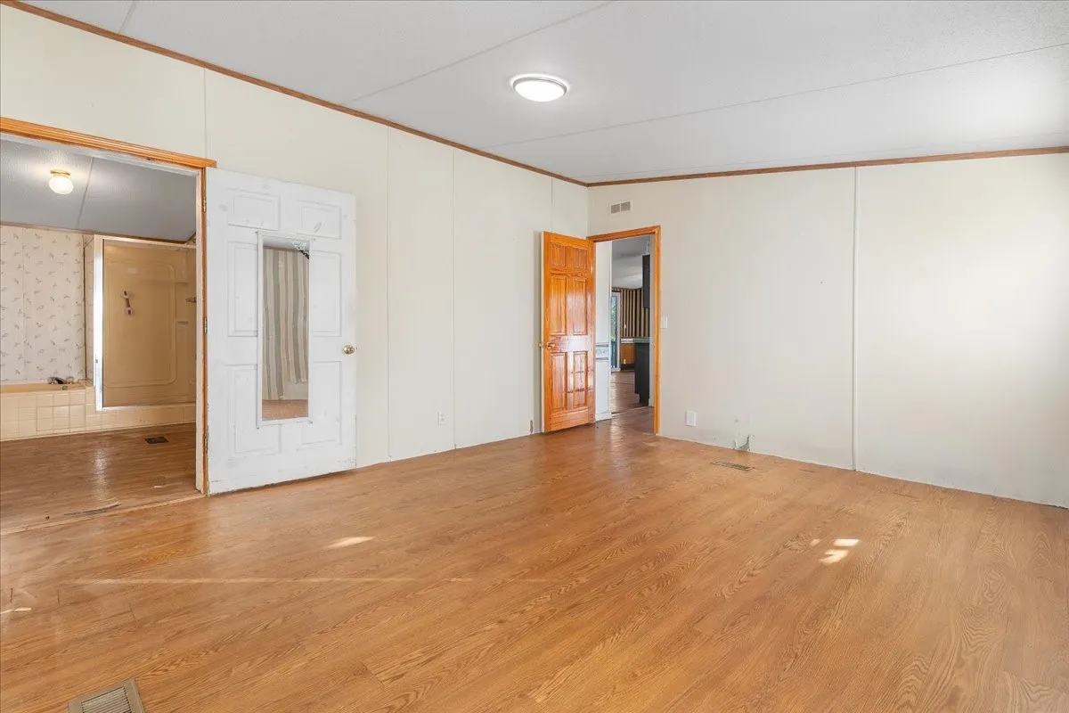 Spare room with wood finished floors and ornamental molding