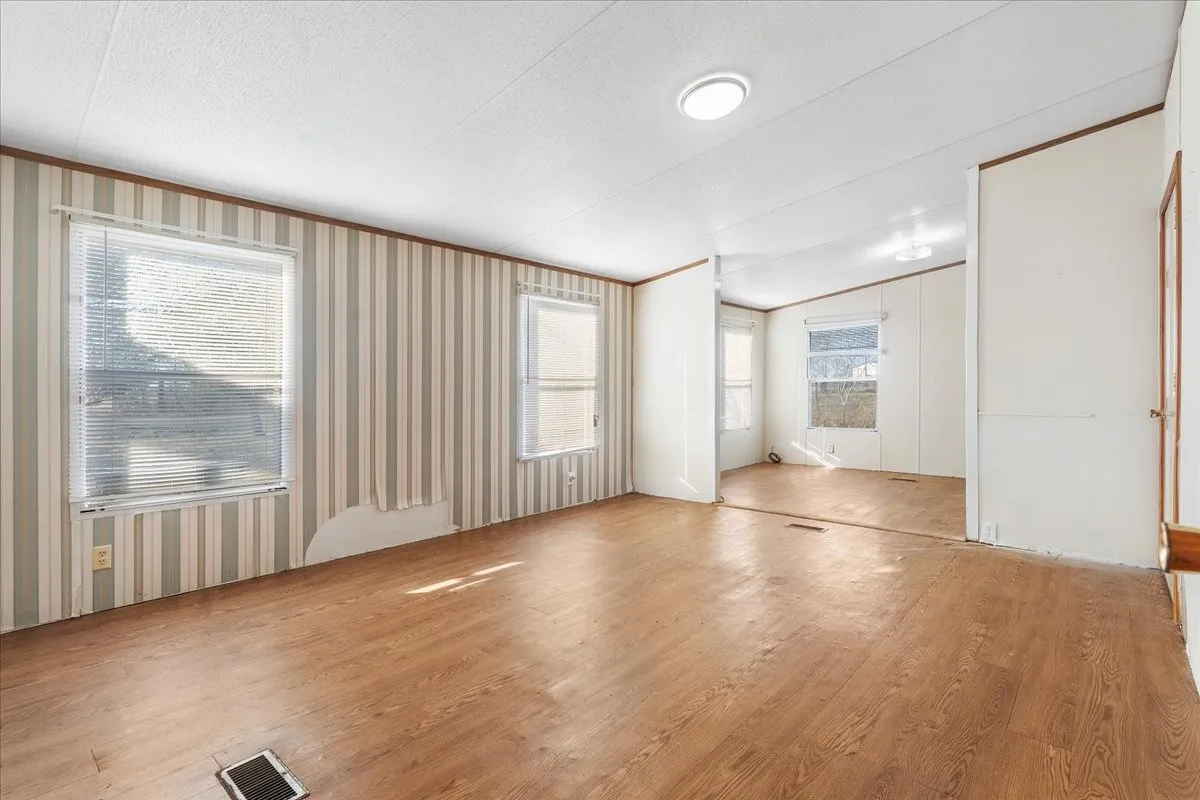 Unfurnished living room featuring wood finished floors and a textured ceiling