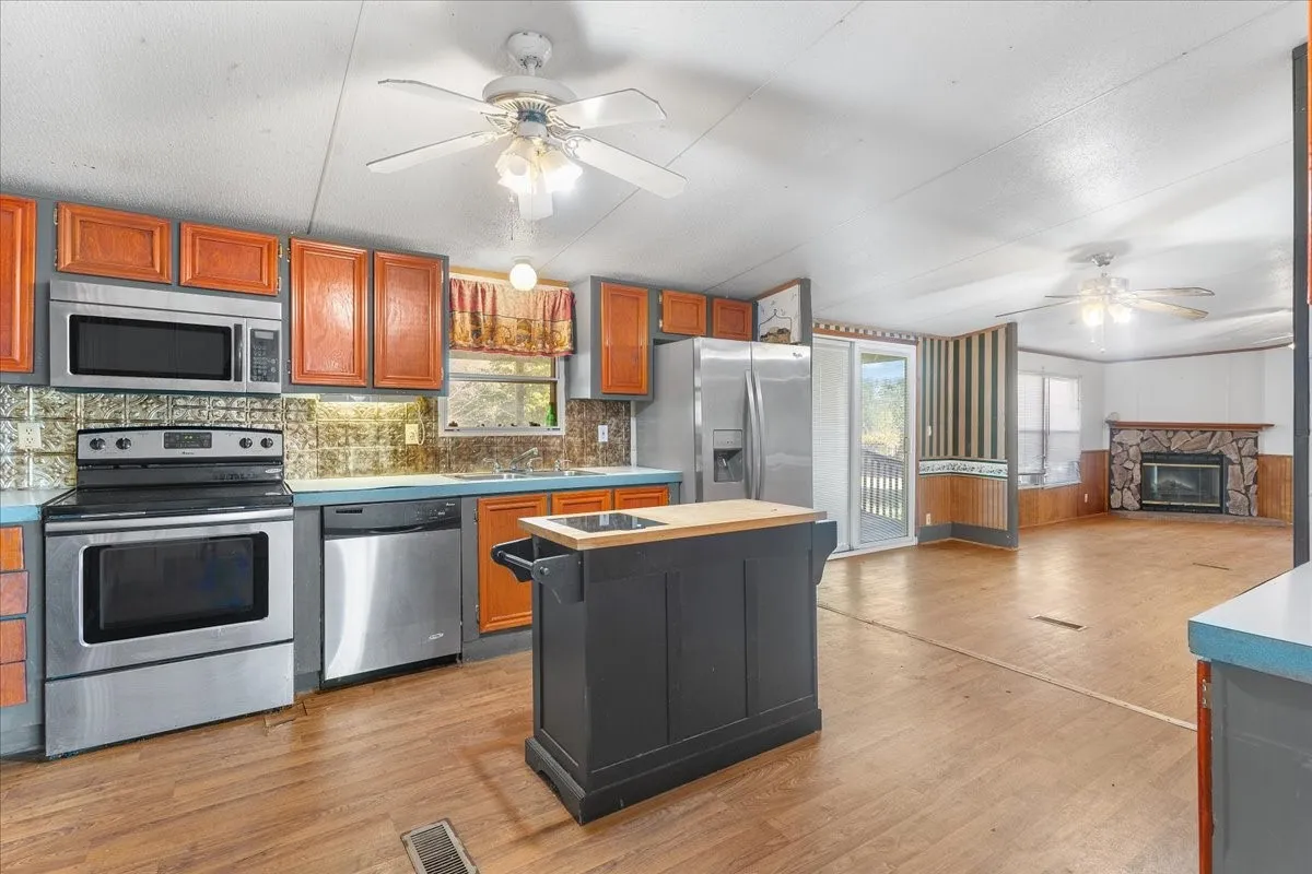 Kitchen with ceiling fan, appliances with stainless steel finishes, plenty of natural light, and a center island