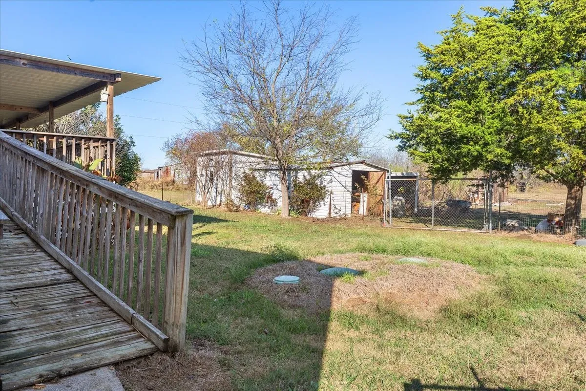 View of yard featuring an outbuilding and a gate