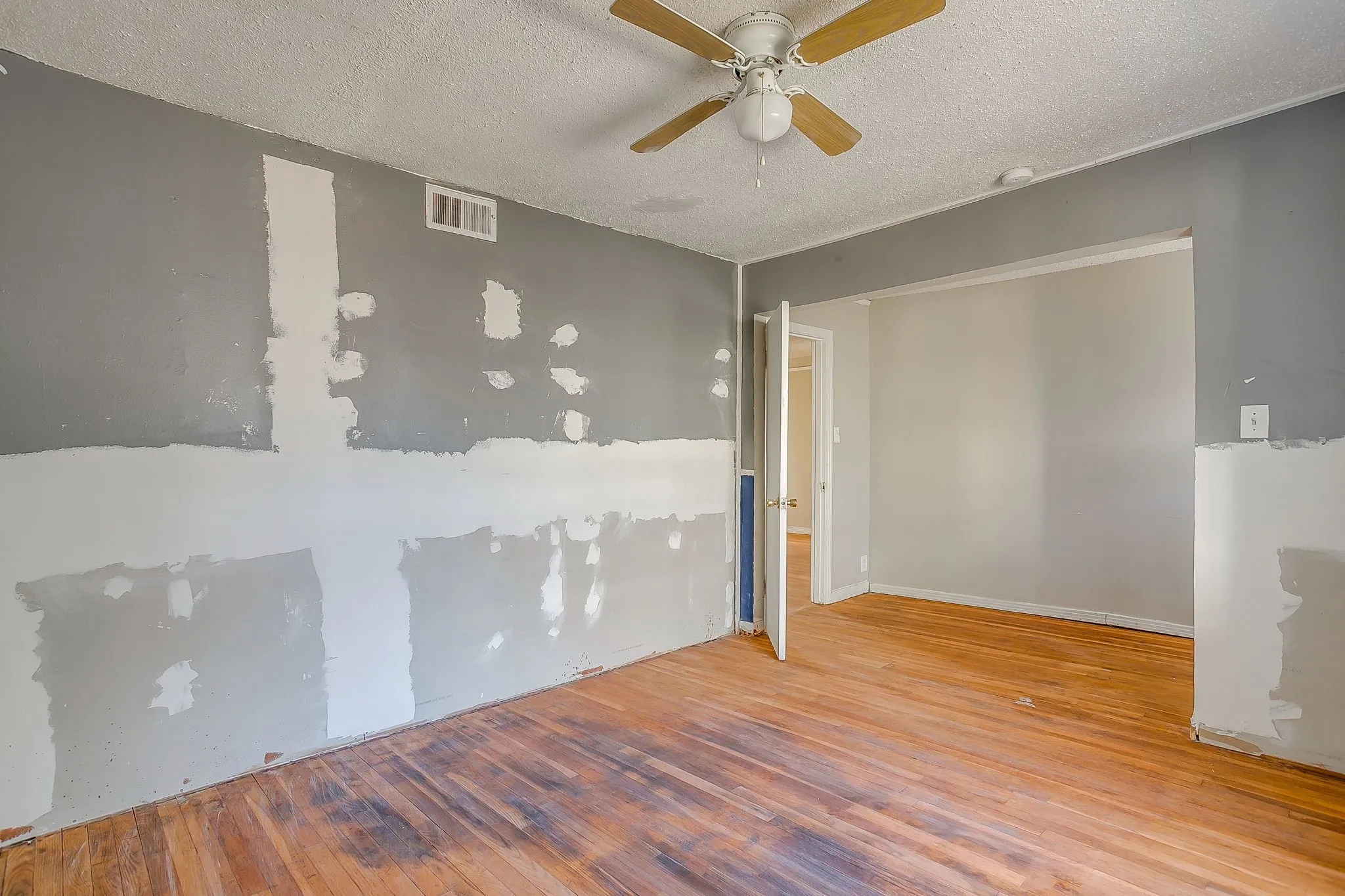 Spare room featuring a textured ceiling, hardwood / wood-style flooring, and ceiling fan