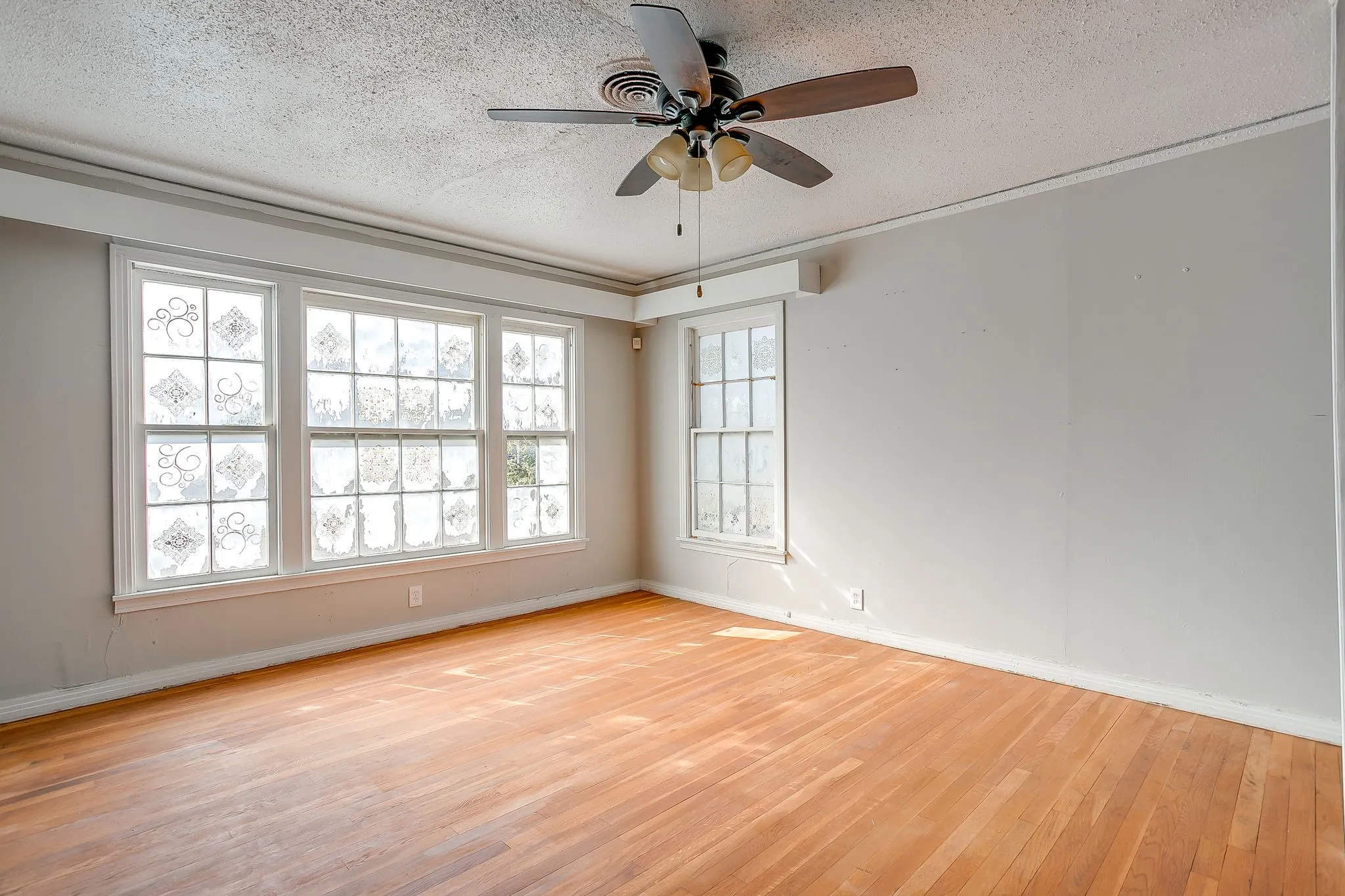 Spare room featuring a textured ceiling, light wood-style floors, and a ceiling fan