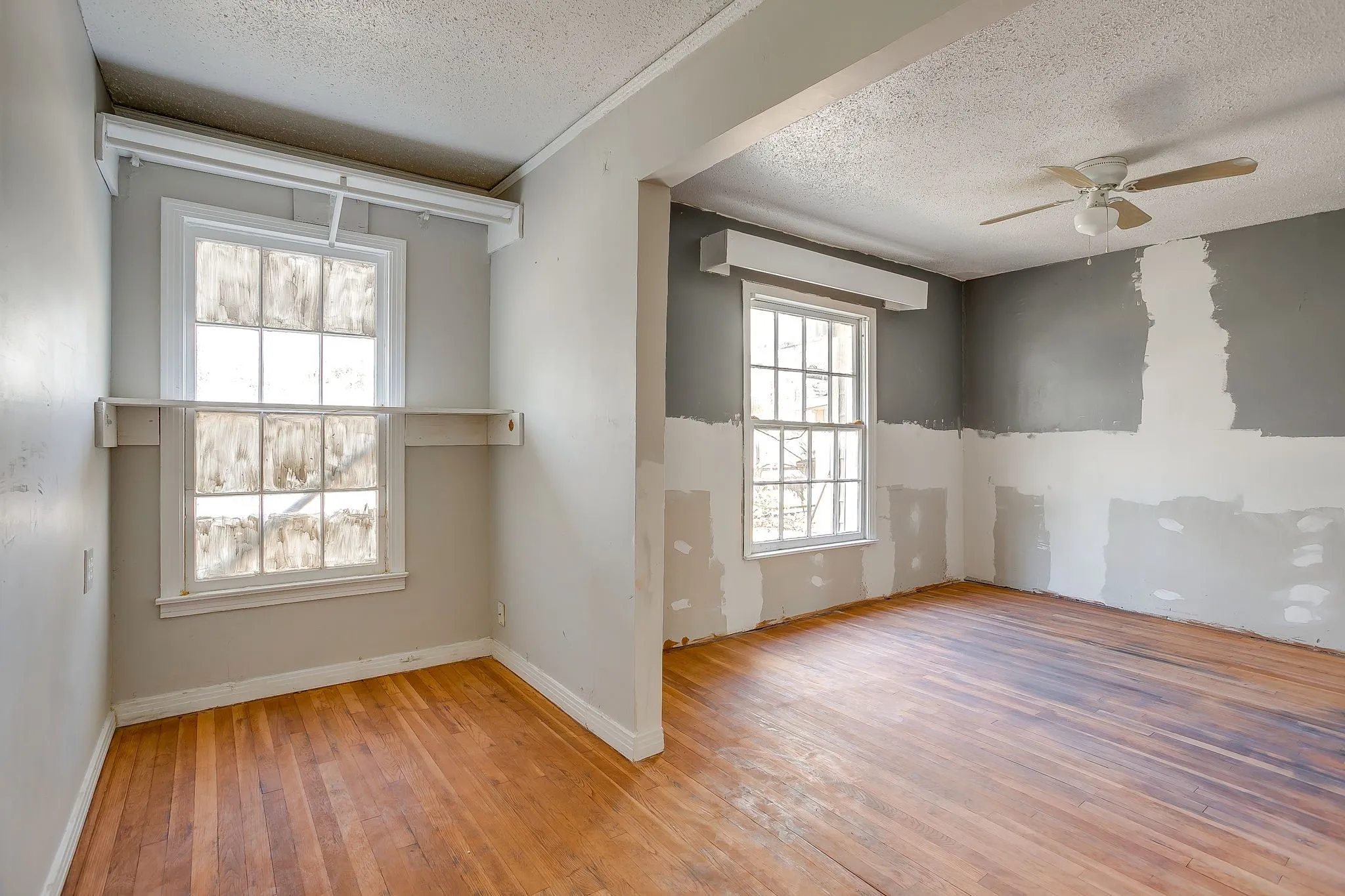 Unfurnished room with a textured ceiling, ceiling fan, and light wood-style floors