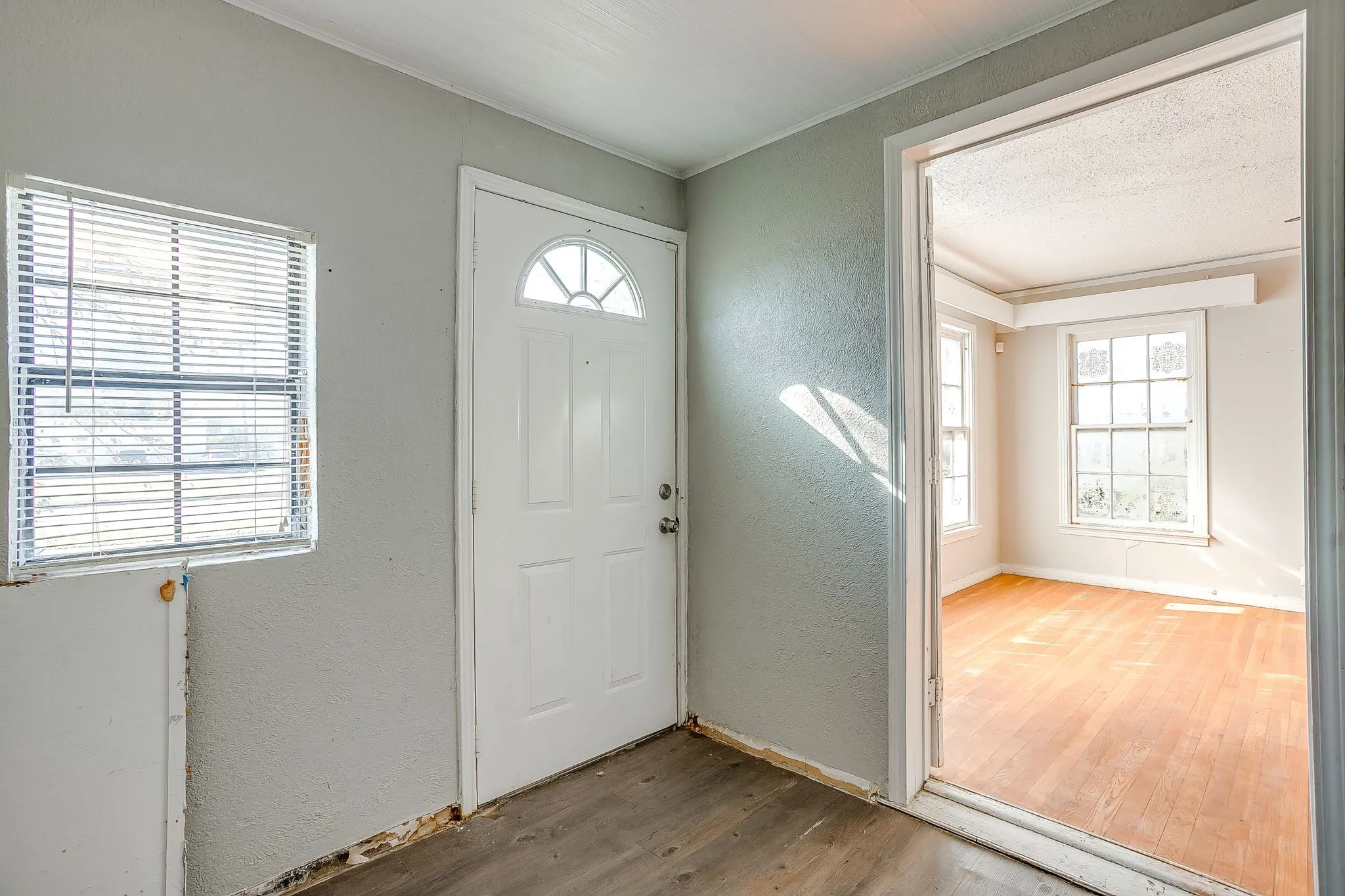 Foyer entrance featuring a textured wall, wood finished floors, and plenty of natural light