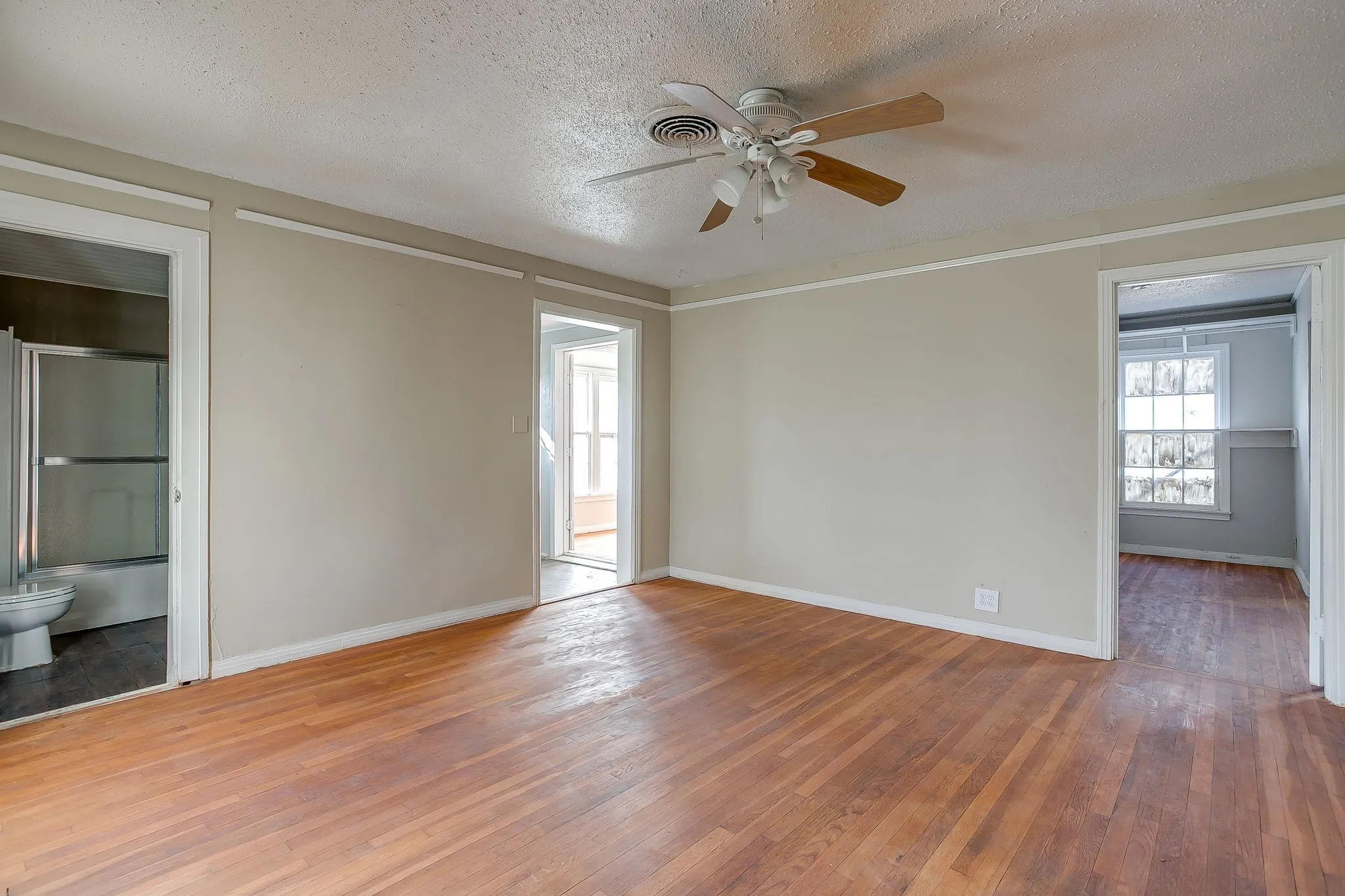 Spare room featuring wood-type flooring, a textured ceiling, and ceiling fan