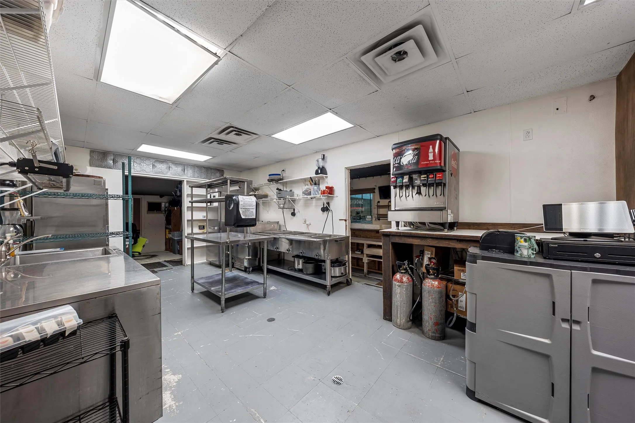 Miscellaneous room featuring a drop ceiling and a workshop area