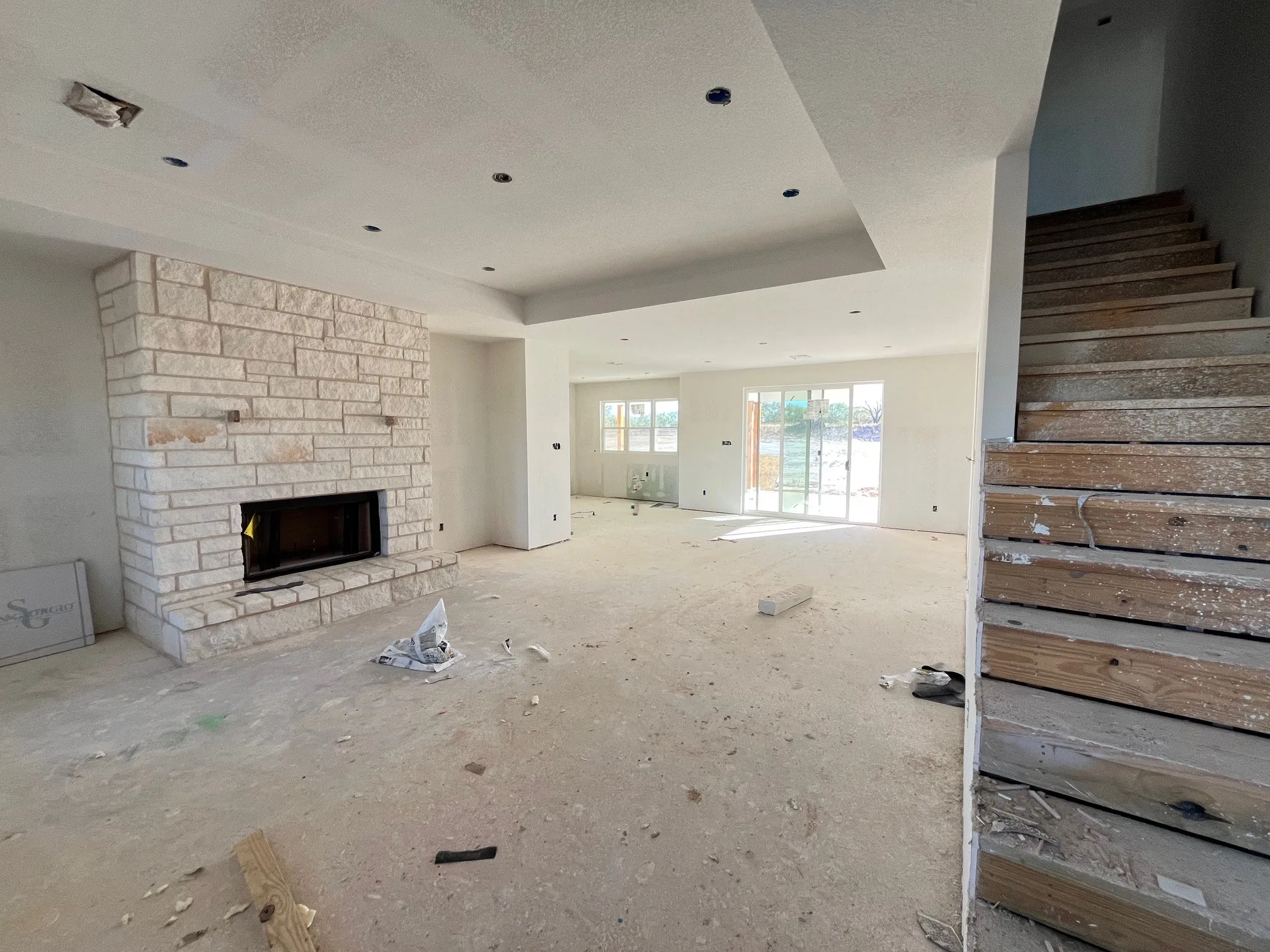 Unfurnished living room with a fireplace, a raised ceiling, and a textured ceiling