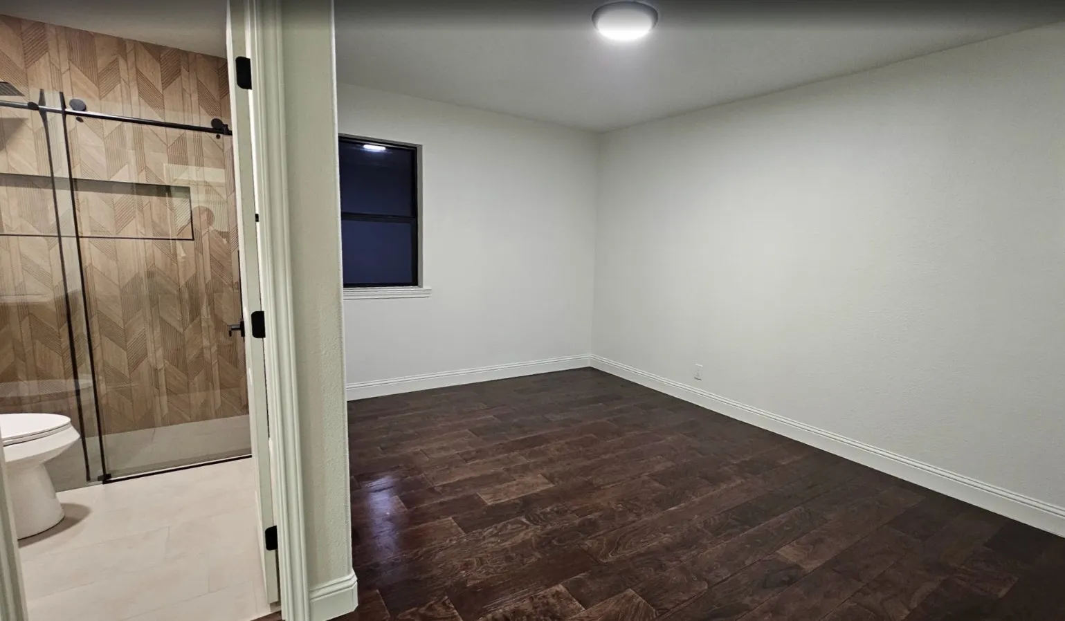 Unfurnished room featuring dark wood-type flooring and baseboards