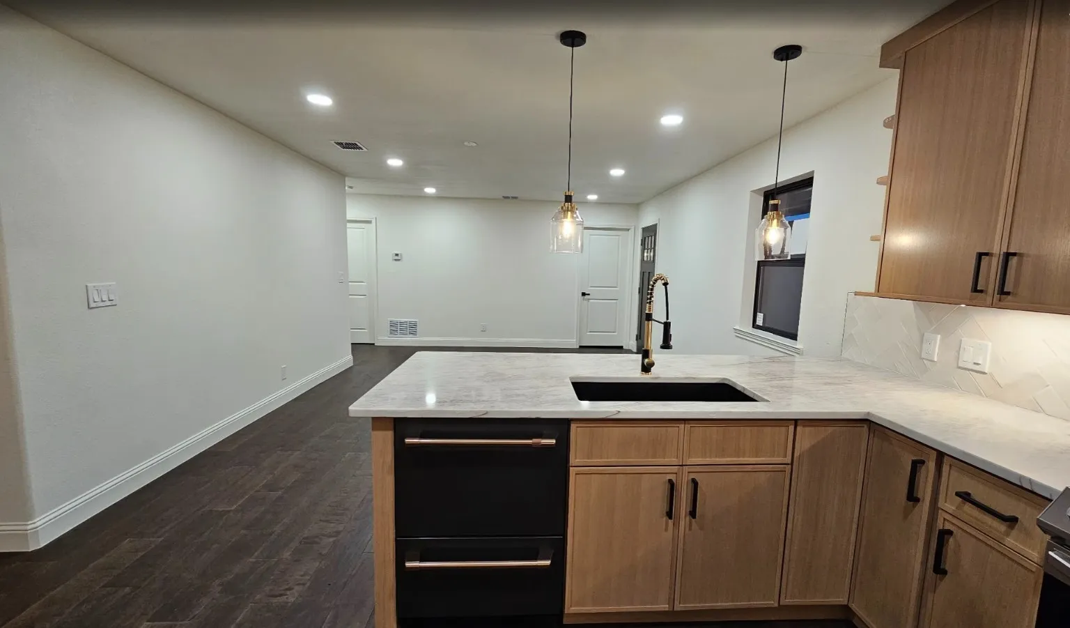 Kitchen featuring a peninsula, recessed lighting, light stone countertops, hanging light fixtures, and dark wood-style floors
