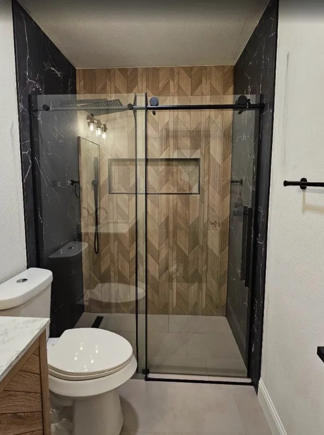 Full bath featuring a stall shower, vanity, and a textured wall