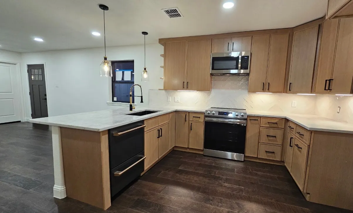 Kitchen with stainless steel appliances, recessed lighting, dark wood-type flooring, light stone countertops, and decorative light fixtures