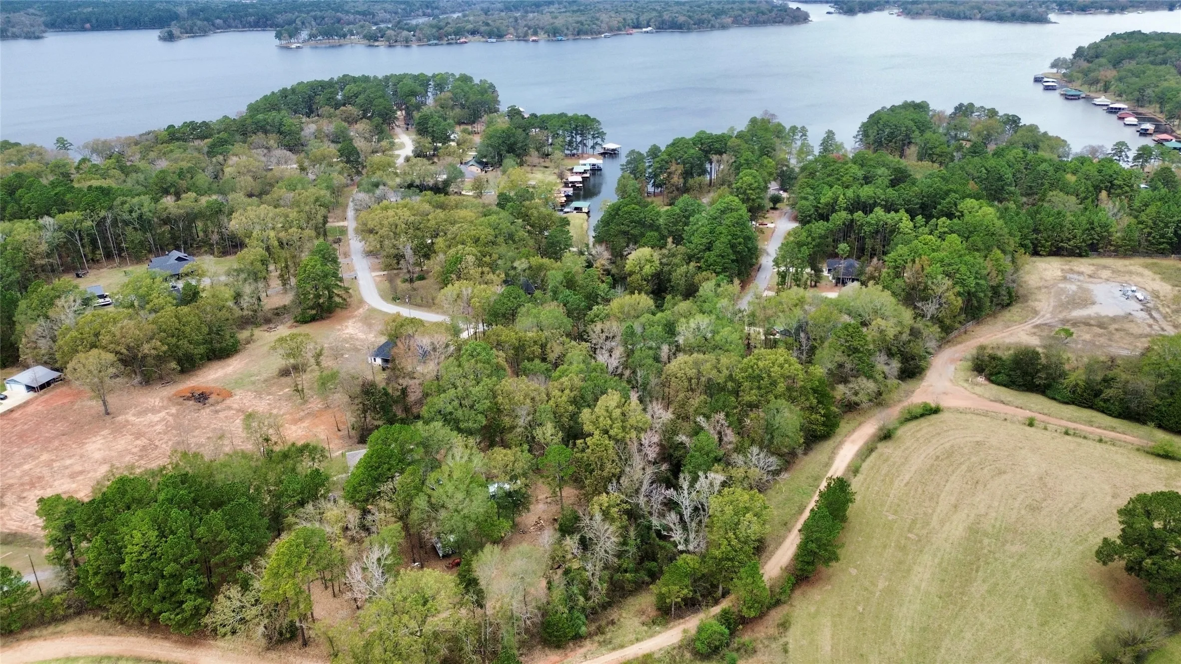 Aerial view of property's location featuring a heavily wooded area and a large body of water