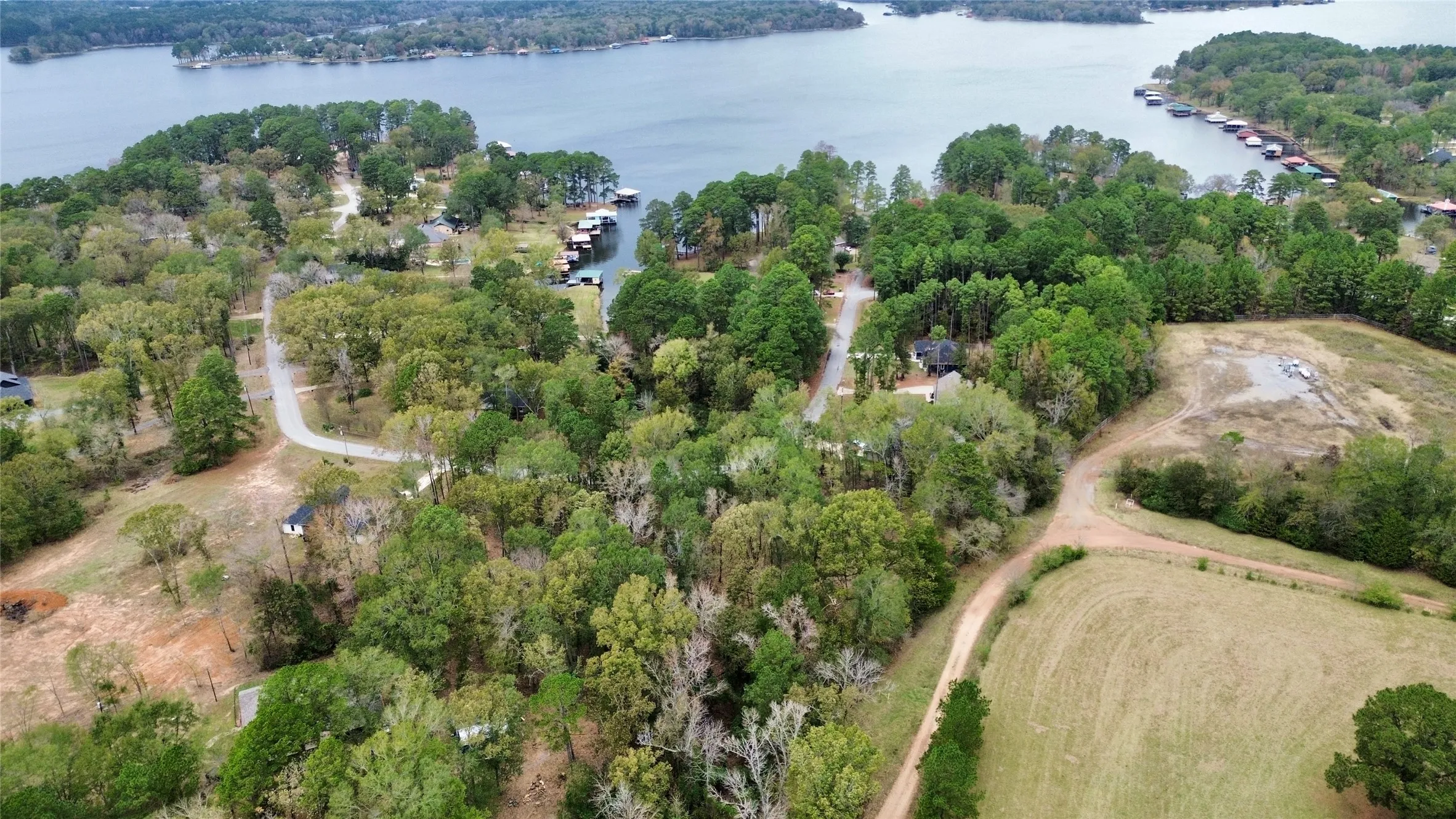 Aerial view of property's location featuring a forest and a large body of water
