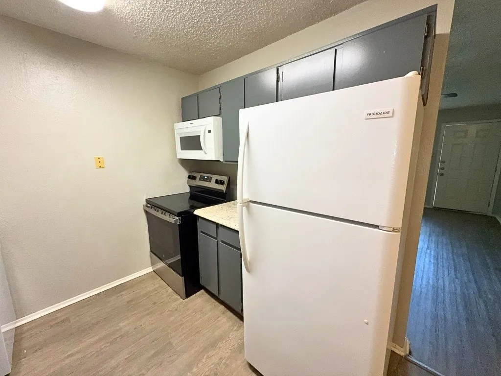 Kitchen with electric range, microwave, dishwasher, and refrigerator