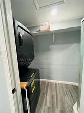 Washroom featuring estacked washer and dryer and light wood-style flooring