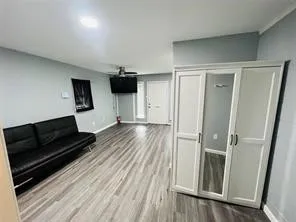 Unfurnished living room featuring baseboards and wood finished floors