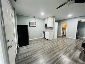 Unfurnished living room with ceiling fan and wood finished floors