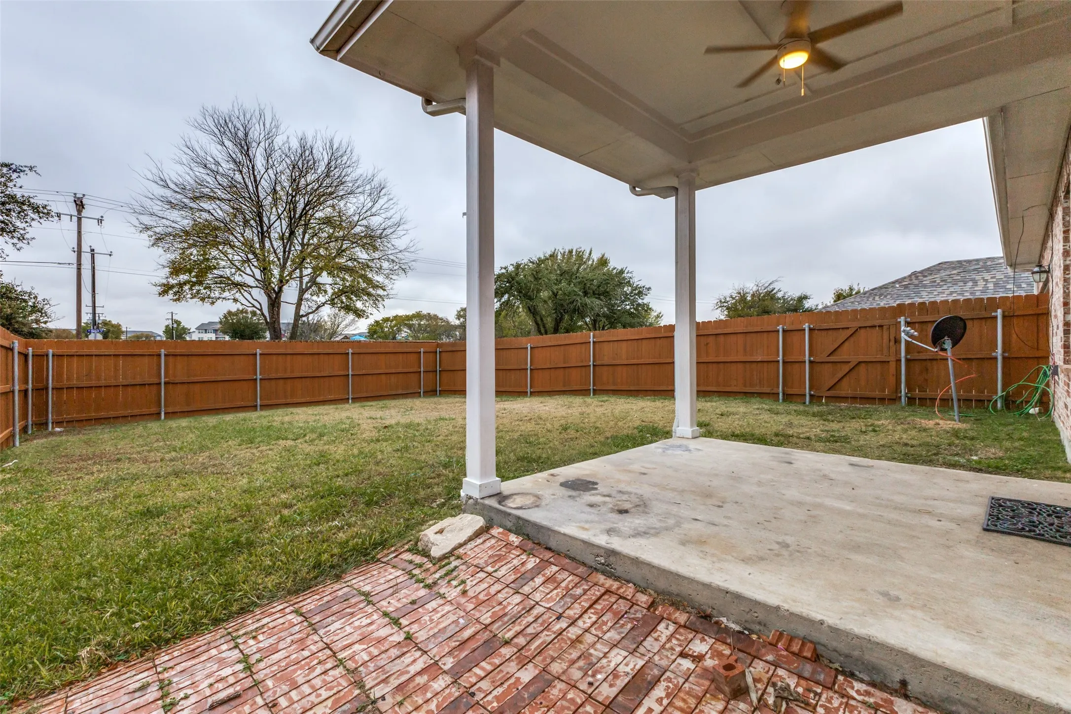 The backyard features a nice covered patio and wood privacy fence.
