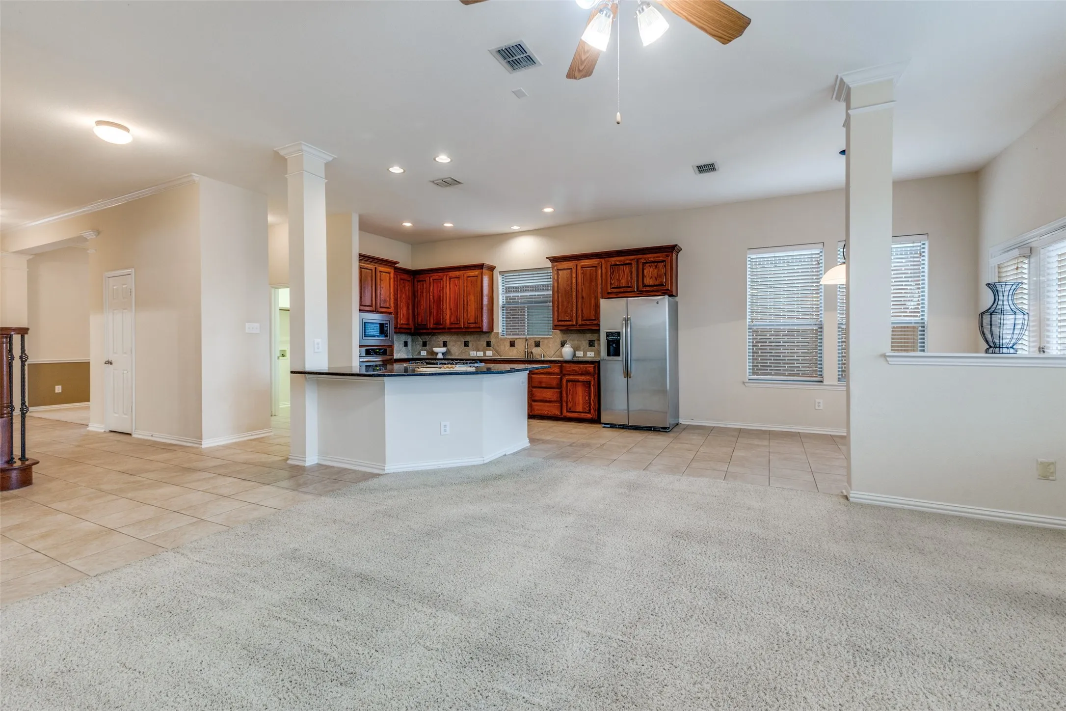 The kitchen has granite counter tops, tile backsplash and large over-sized island with cooktop and storage.