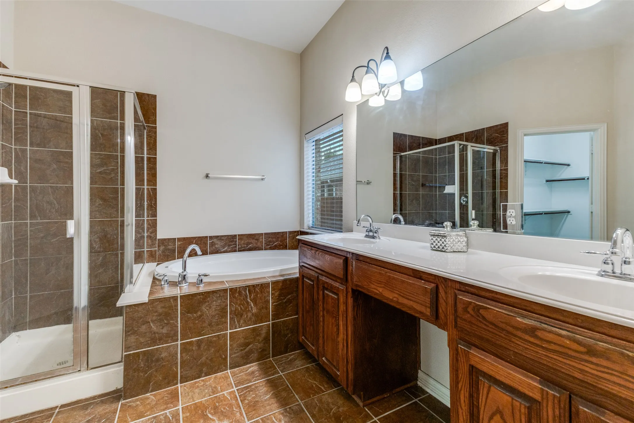 This primary bath features dual vanities, garden tub and separate shower.