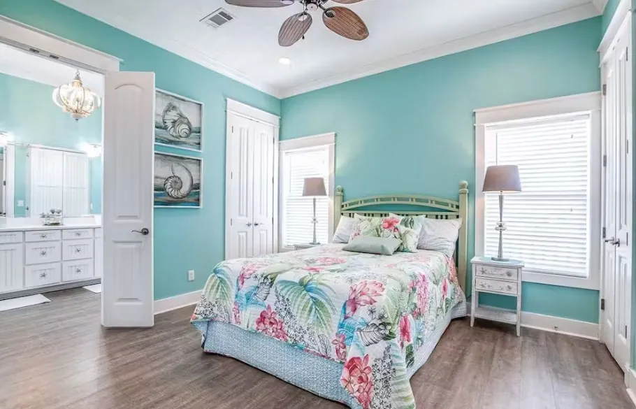 Bedroom with crown molding, dark wood finished floors, a ceiling fan, a closet, and ensuite bathroom