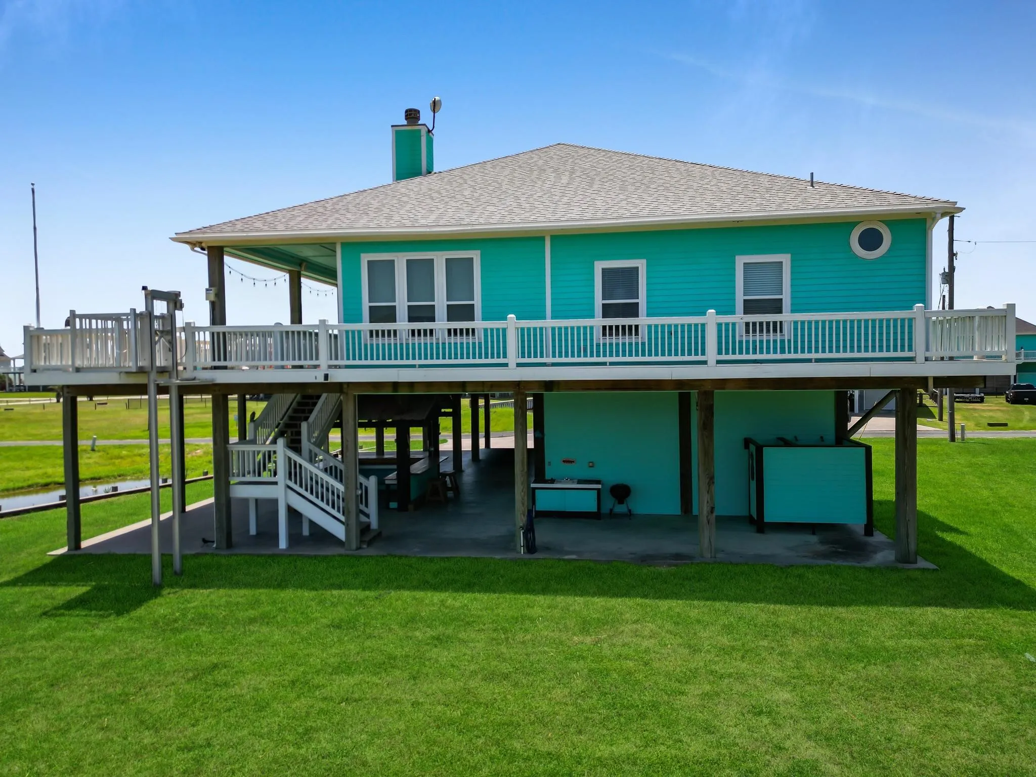 Stilted architecture with a turquoise exterior and white trim
