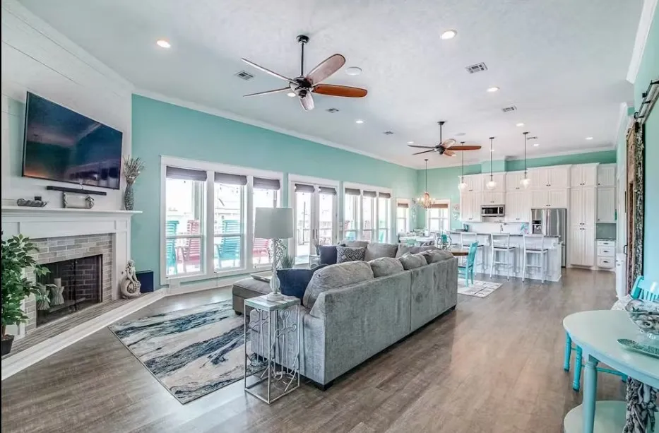 Living area featuring crown molding, dark wood-type flooring, a brick fireplace, a ceiling fan, and recessed lighting