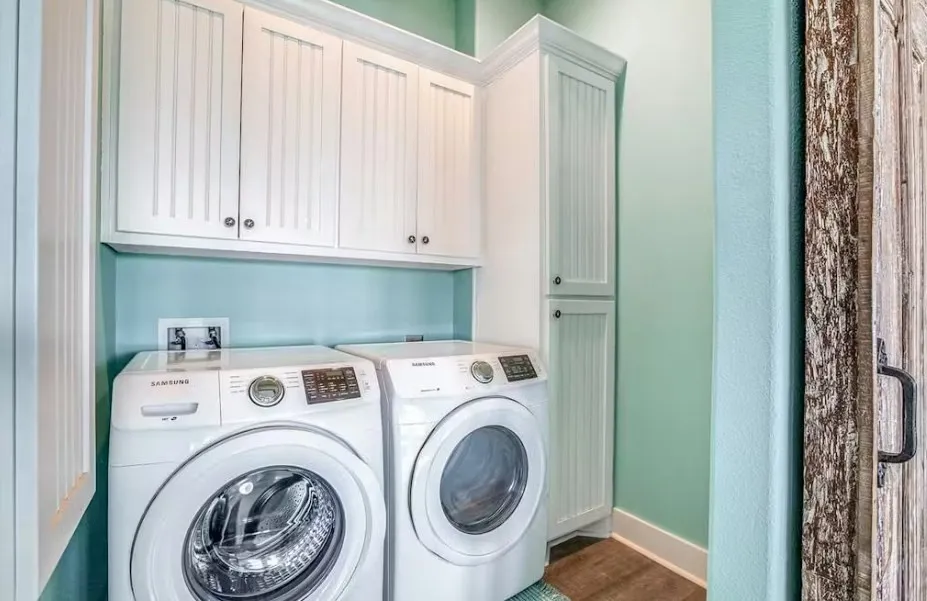 Washroom with cabinet space, separate washer and dryer, and dark wood-style floors